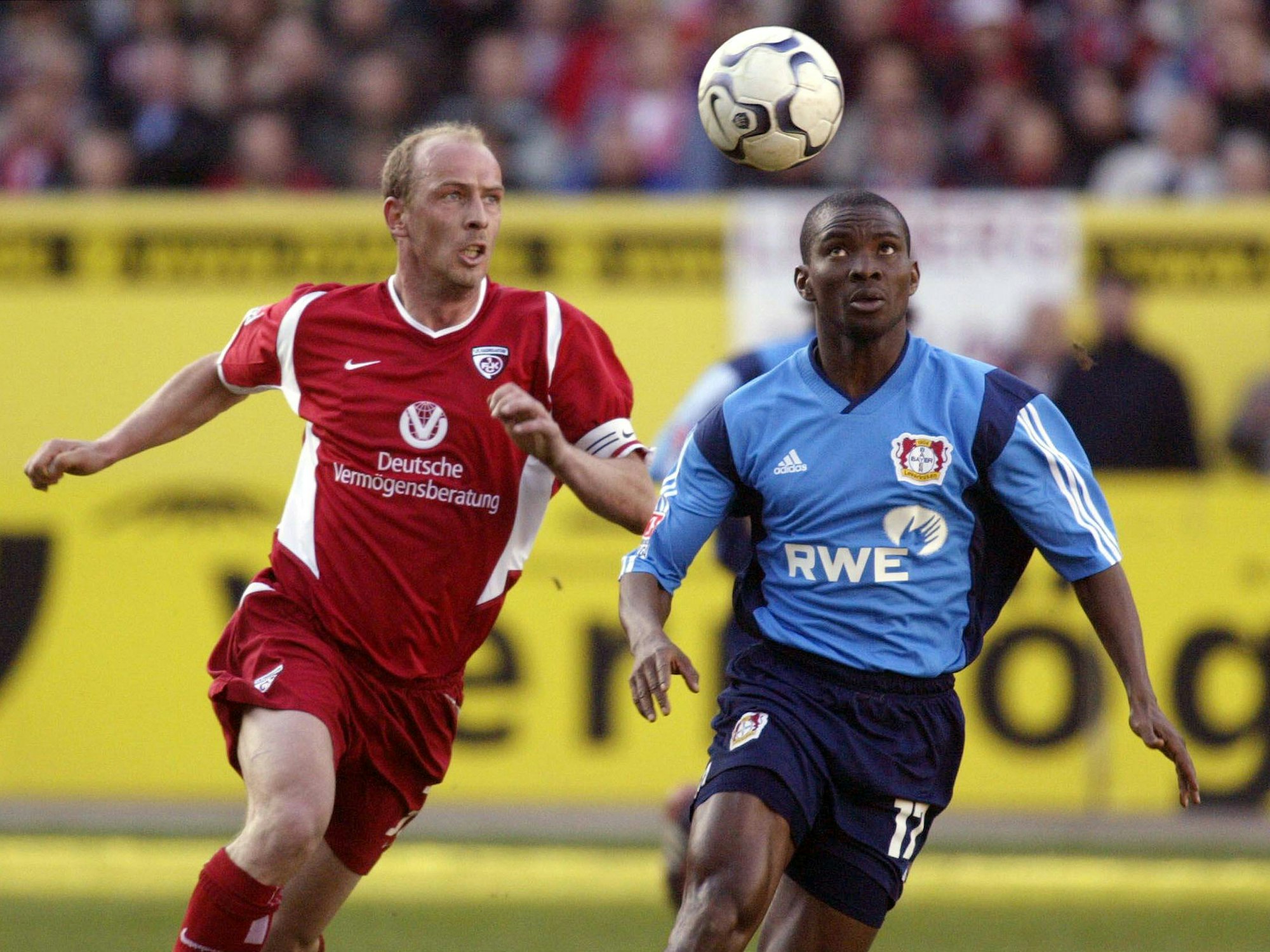 Ojigwe und Mario Basler rennen dem Ball hinterher, der durch die Luft fliegt.