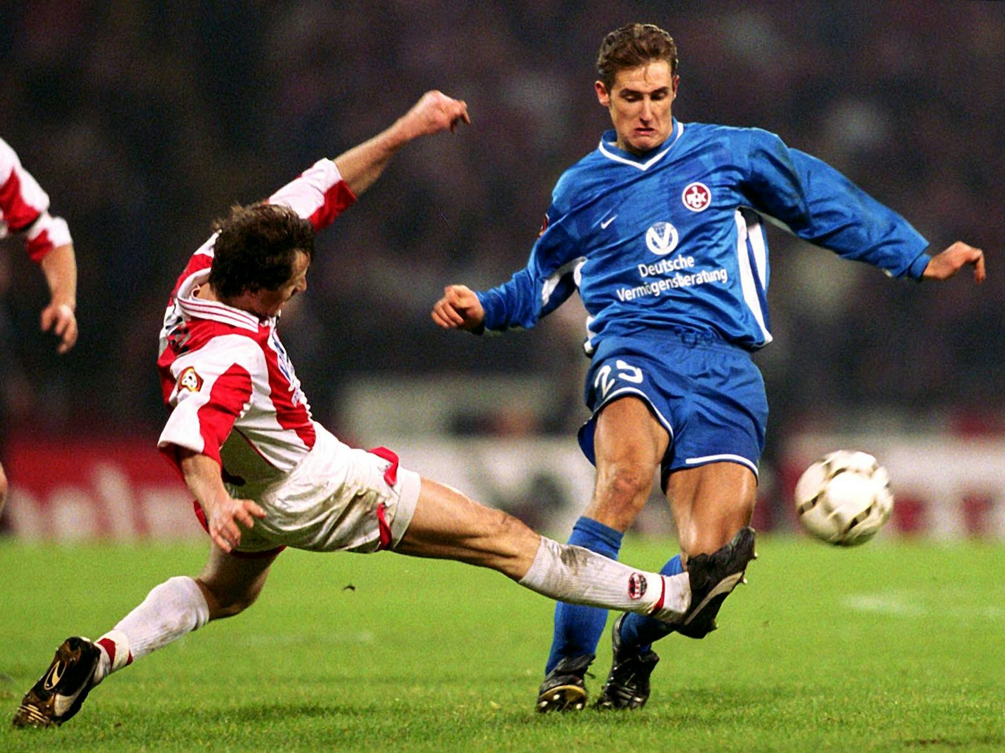 Kölns Jens Keller grätscht nach dem Ball, Klose hat Probleme den Ball zu kontrollieren.