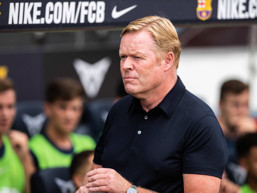 Koeman steht vor der Trainerbank.