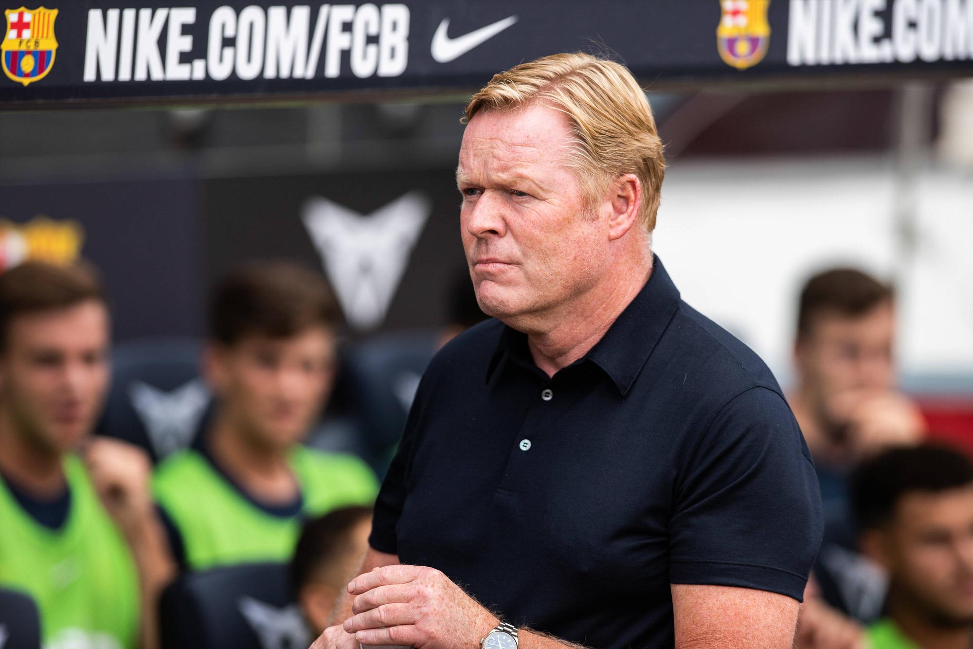 Koeman steht vor der Trainerbank.