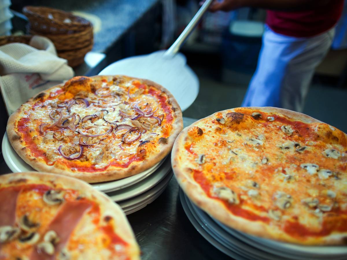 Wer Hunger auf Pizza hat, sollte in NRW bestellen. Das Online-Portal Speisekartenweb.de hat die Preise analysiert. Unser Foto zeigt, wie eine Pizza auf einen Teller geschoben wird.