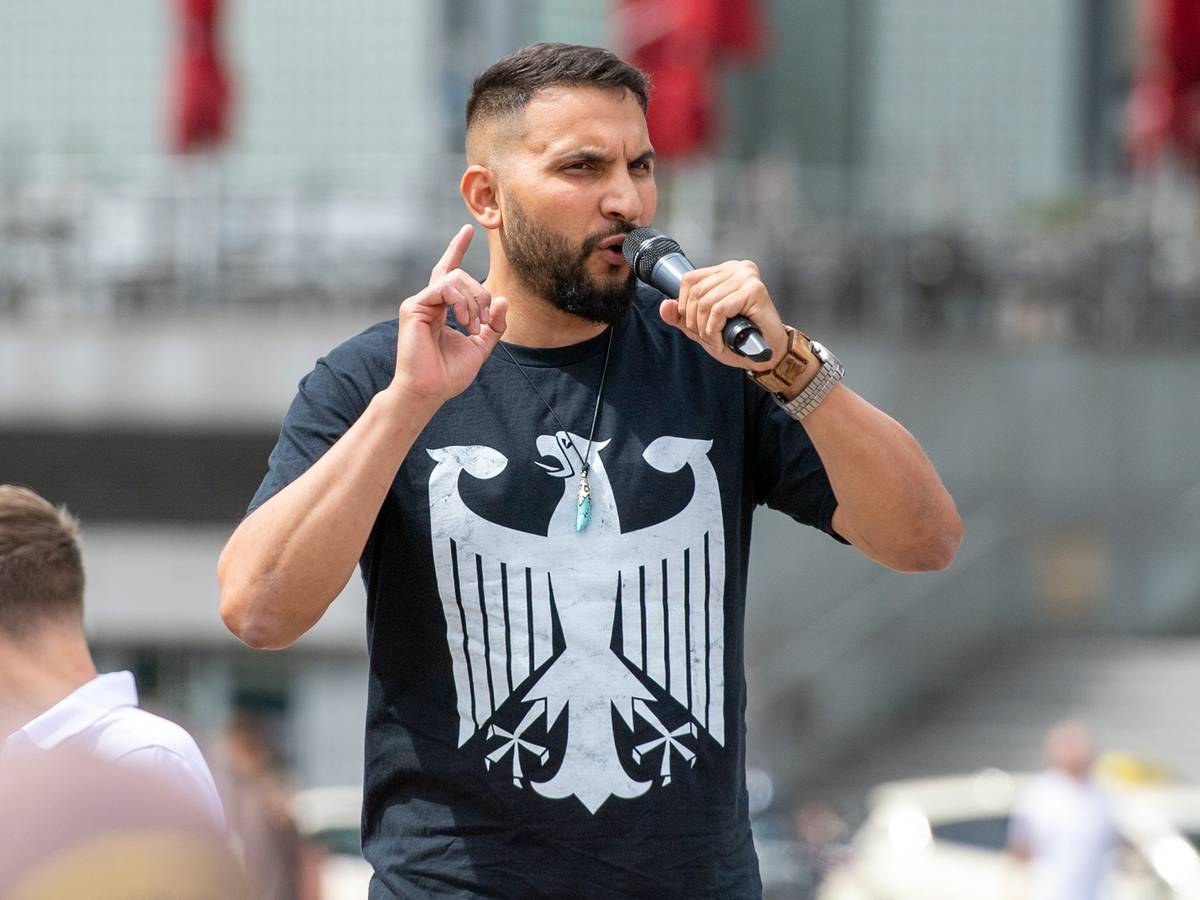 Der Verschwörungsprediger Attila Hildmann spricht im Juli 2020 bei einer Anti-Corona-Demo in Berlin. Er trägt ein schwarzes Shirt mit dem Bundesadler.