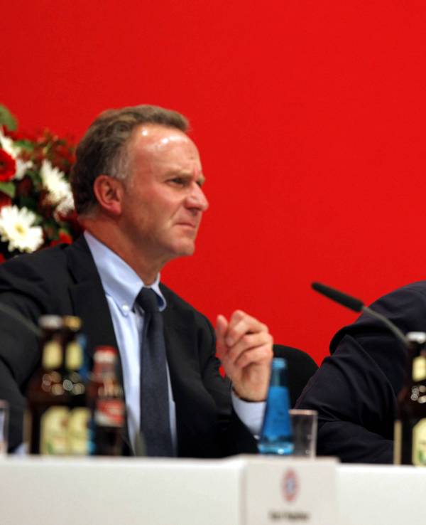 Rummenigge sitzt links neben dem wütenden Hoeneß auf der Bühne bei der Jahreshauptversammlung im Jahr 2007.