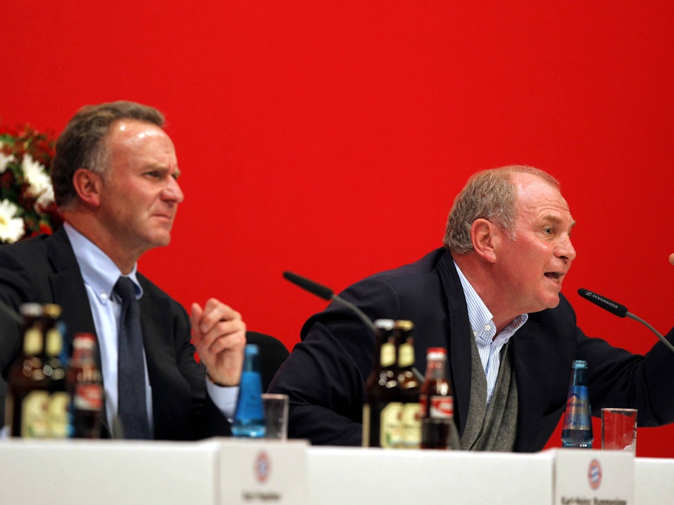 Rummenigge sitzt links neben dem wütenden Hoeneß auf der Bühne bei der Jahreshauptversammlung im Jahr 2007.