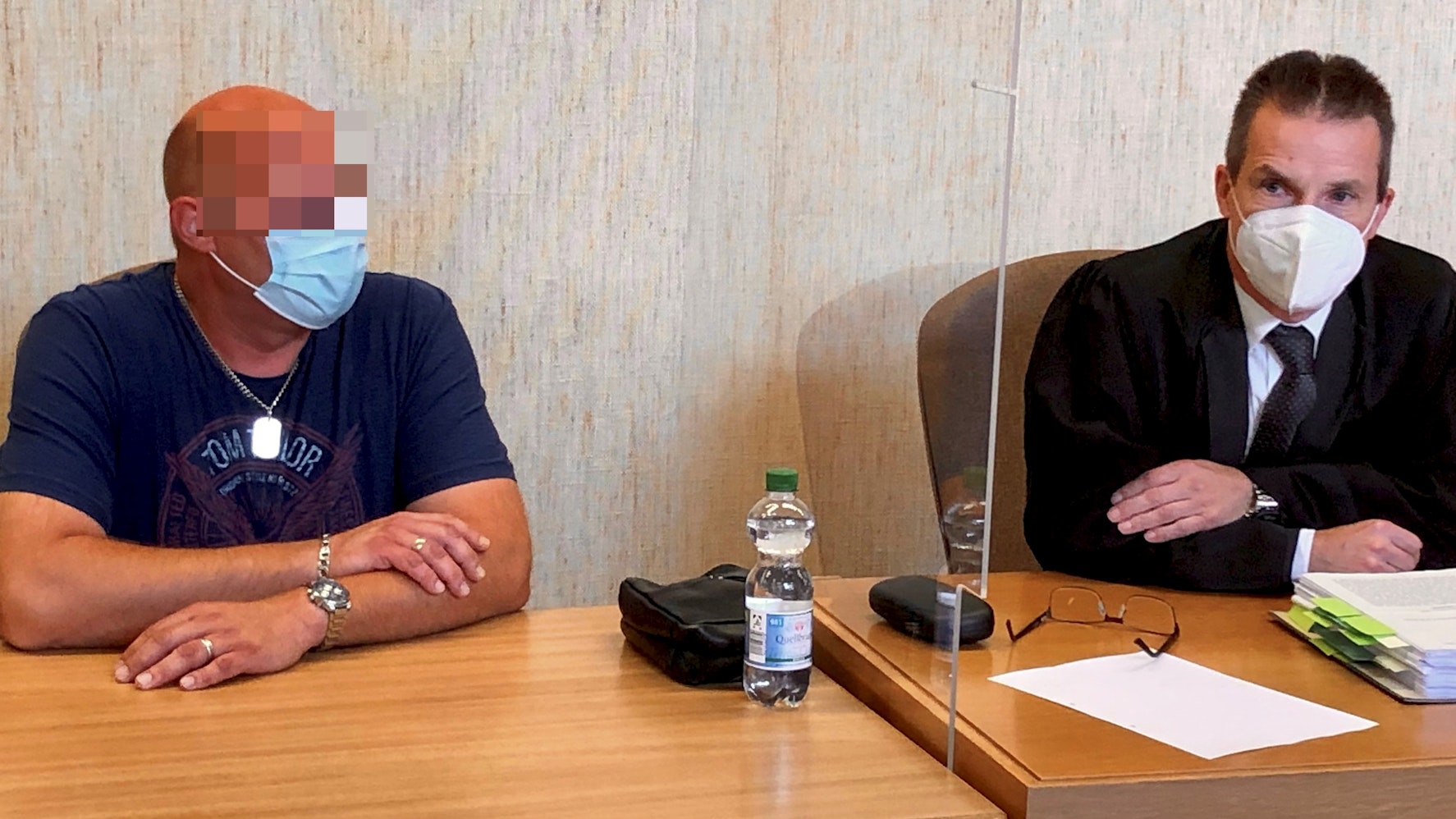 Zwei Männer sitzen an einem Tisch.