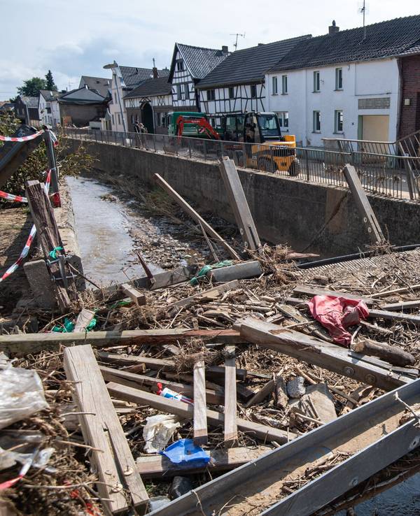 Zerstört ist diese Brücke über den Orbach. Nach der Flutkatastrophe laufen in den betroffenen Regionen in NRW neben den Aufbauarbeiten (wie hier am 27. Juli 2021 in Swisttal) nun auch die Aufbauhilfen.