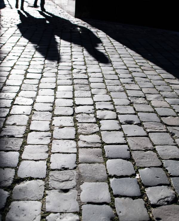 Fußgänger werfen am 21. Januar 2019 in der Aachener Innenstadt ihre Schatten auf das Pflaster.