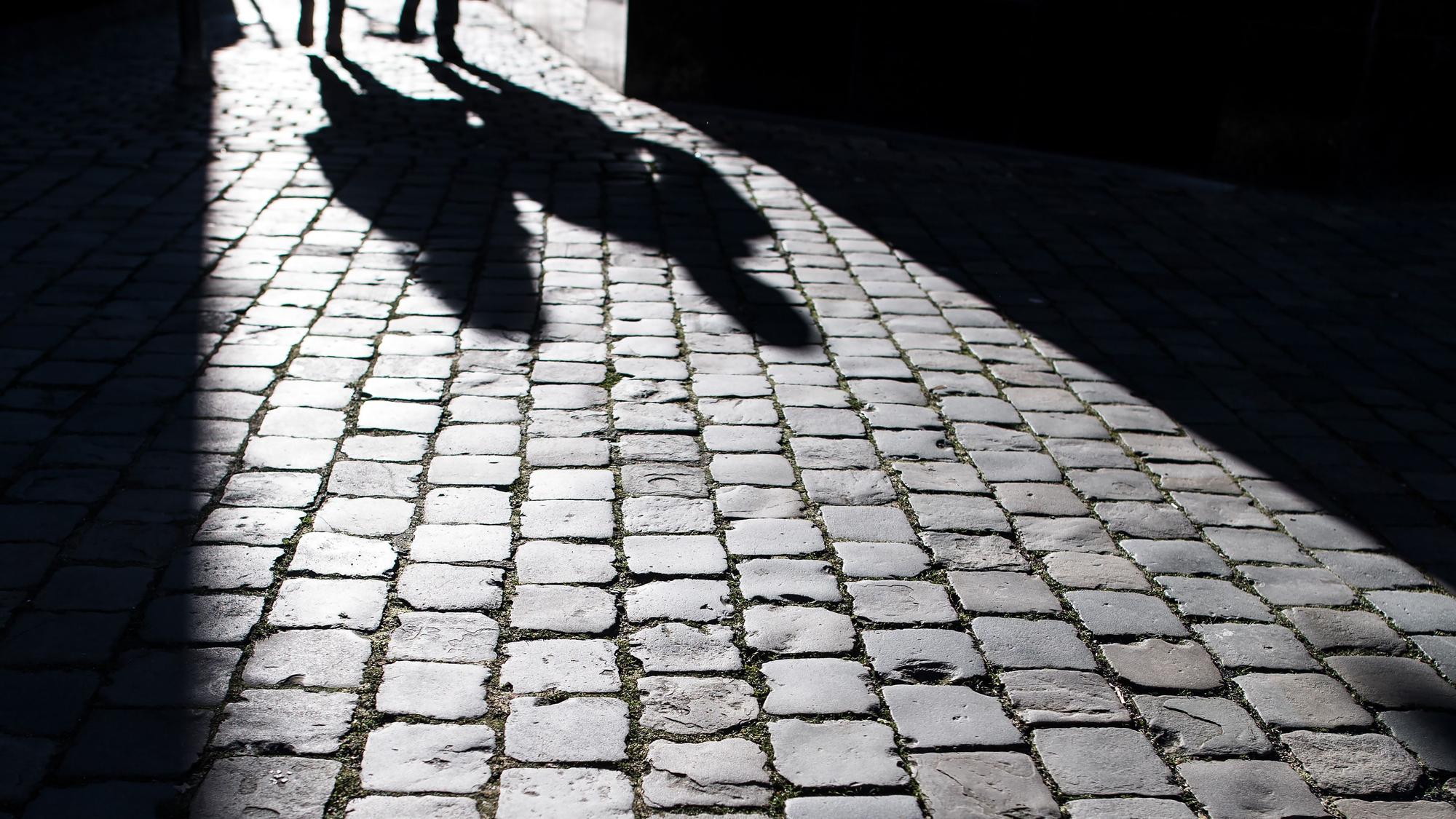 Fußgänger werfen am 21. Januar 2019 in der Aachener Innenstadt ihre Schatten auf das Pflaster.