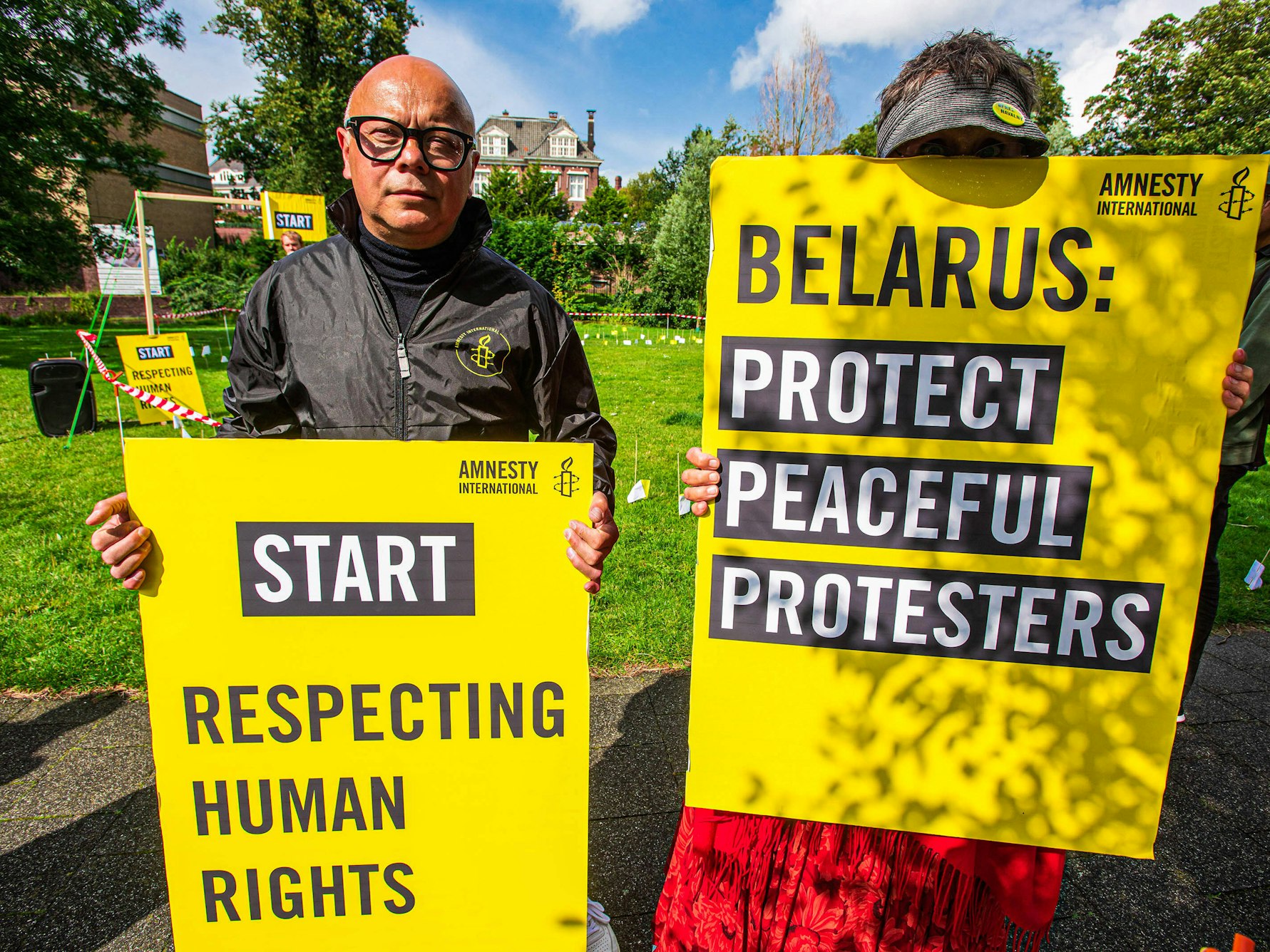 Amnesty-Aktivisten halten Schilder hoch, die auf Englisch die Einhaltung der Menschenrechte in Belarus fordern.