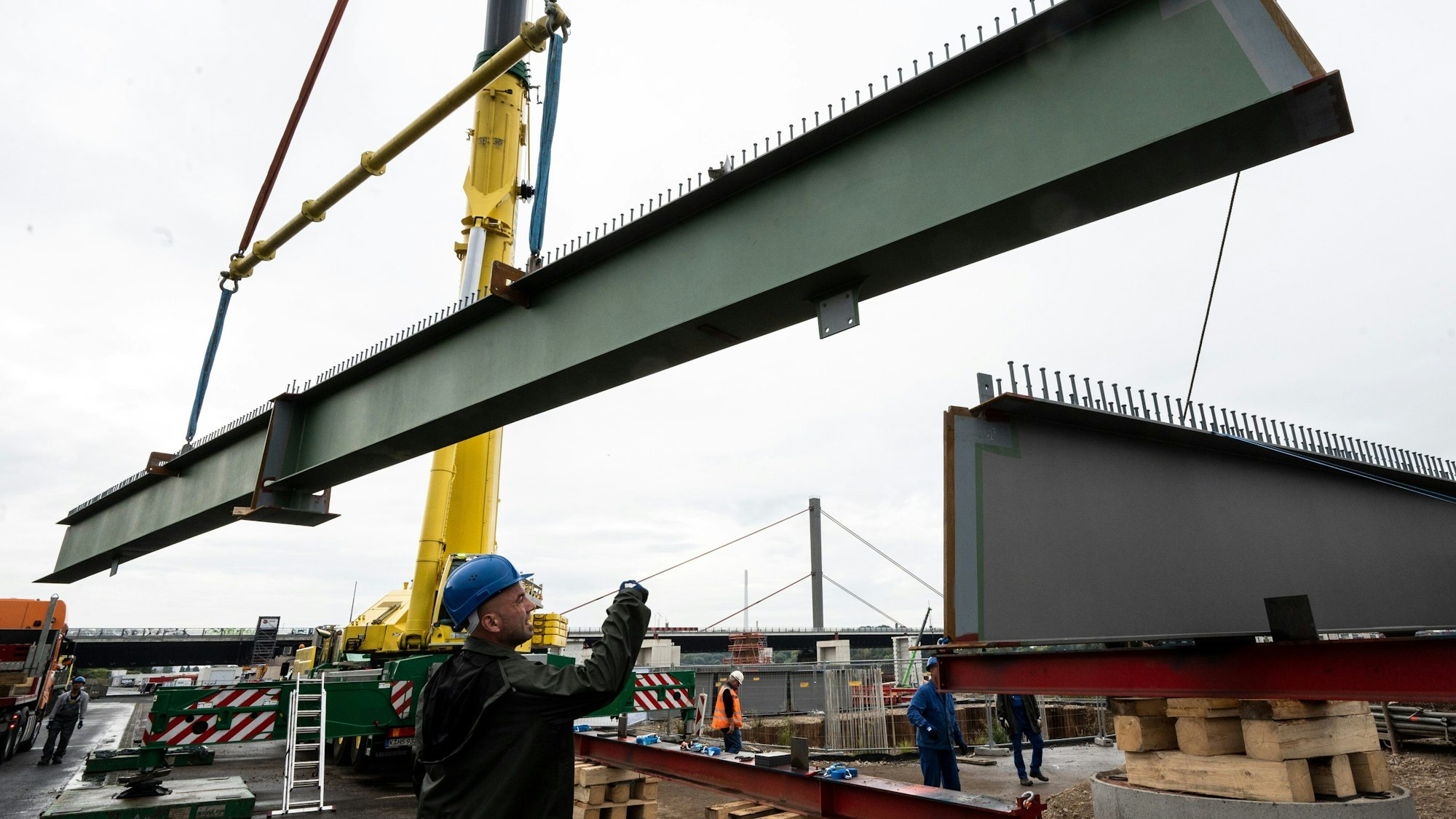 15.09.2021, Nordrhein-Westfalen, Leverkusen: Querträger aus Stahl für die neue Rheinbrücke werden mit einem Kran in Position gebracht.+