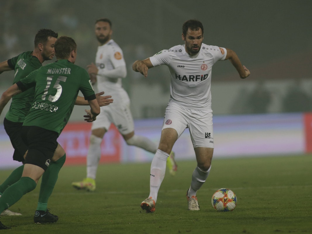 Simon Engelmann behauptet den Ball gegen zwei Spieler von Preußen Münster