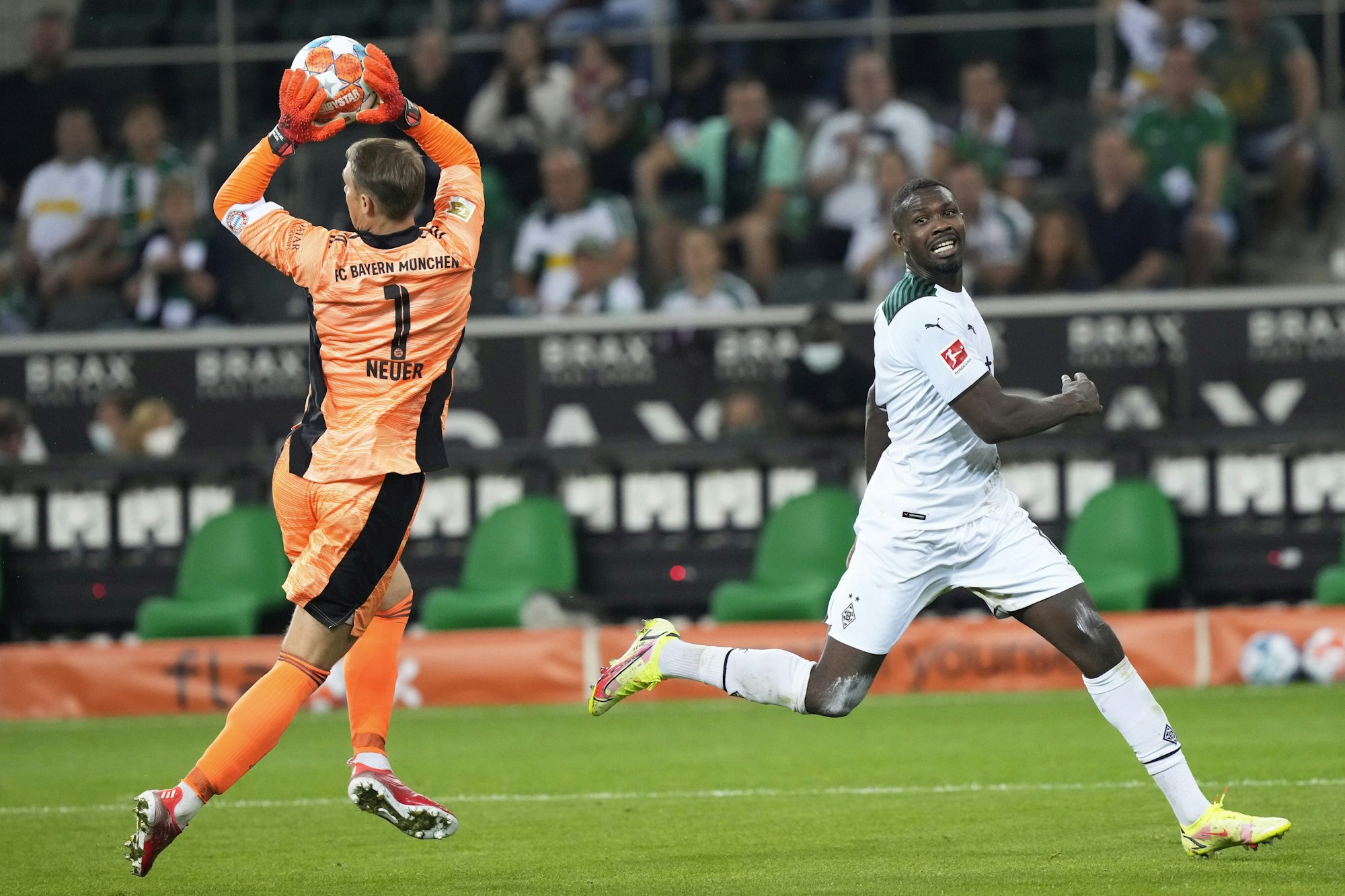 Manuel Neuer hat den Ball vor Marcus Thuram