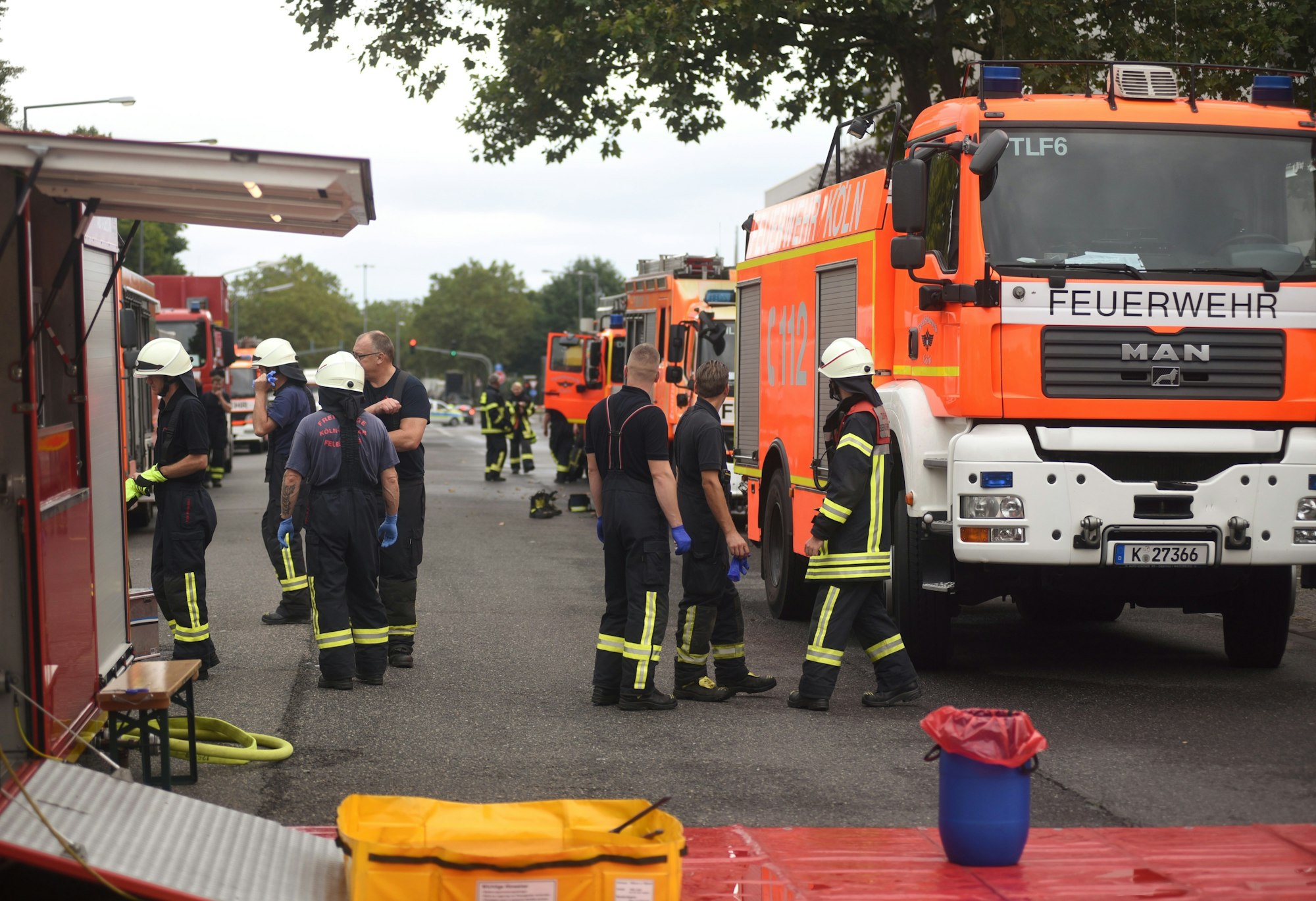 Die Feuerwehr Köln steht in Uniform vor dem Werk von Coca-Cola in Ossendorf.