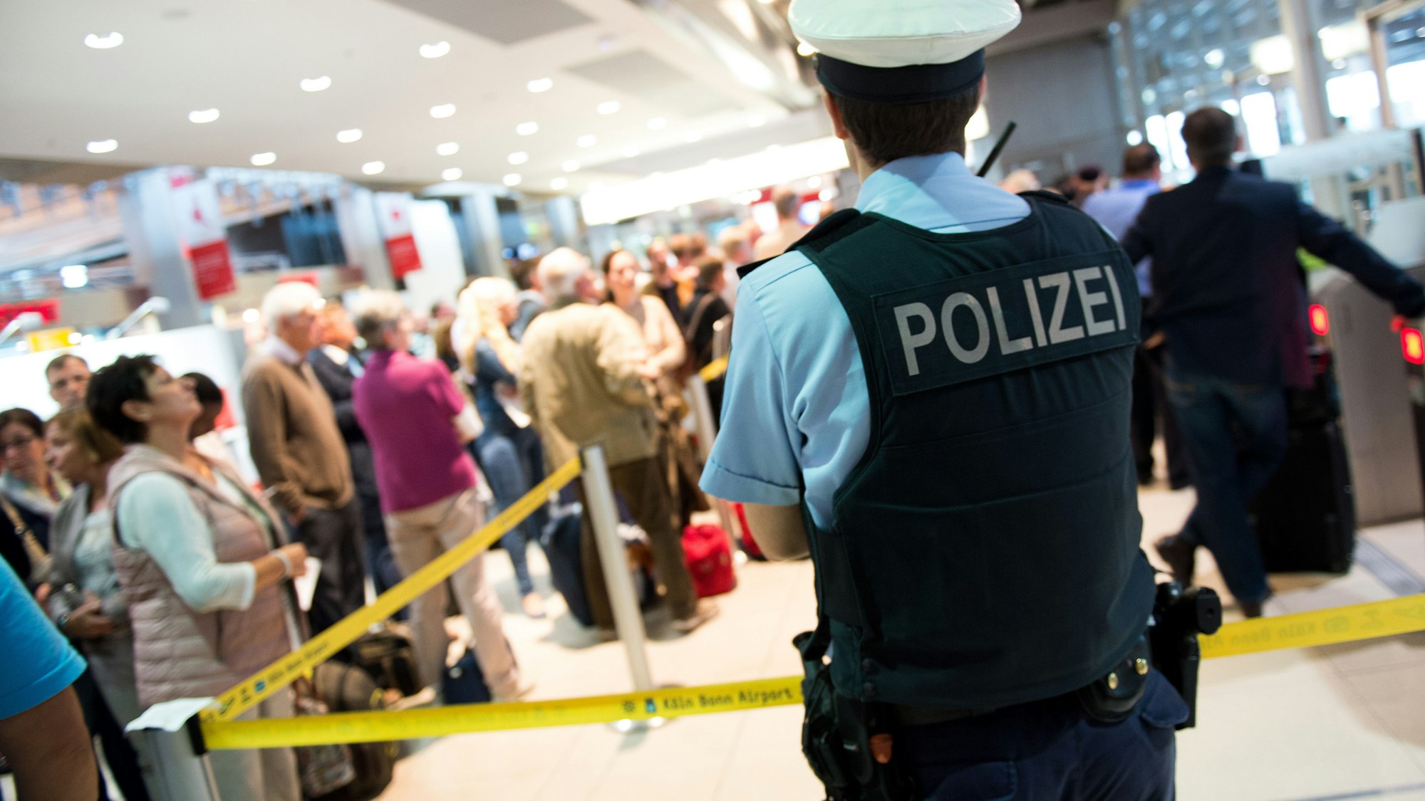 Ein Polizist steht vor dem Sicherheitsbereich im Terminal 1 am Flughafen Köln/Bonn.