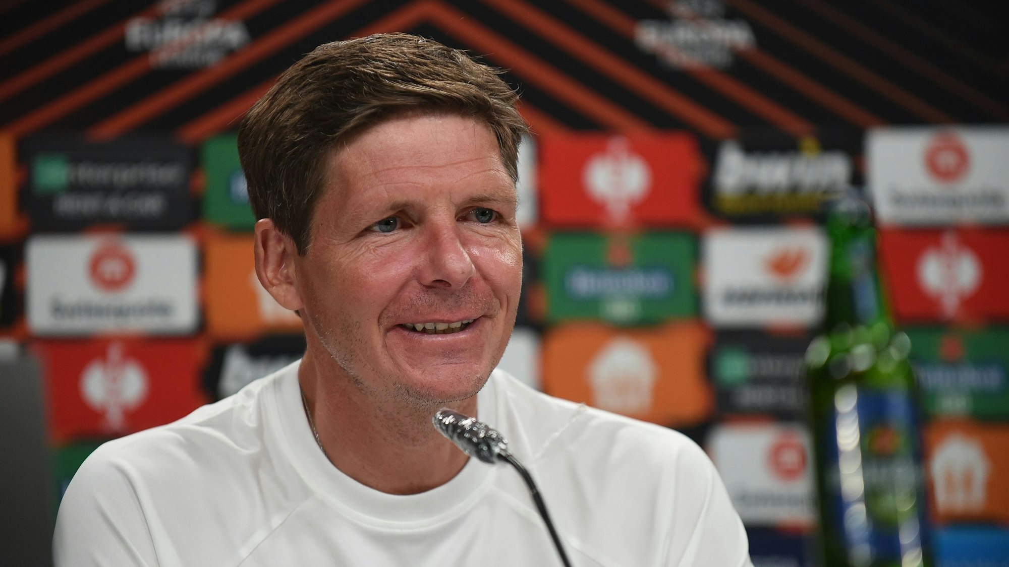 Oliver Glasner lacht während einer Pressekonferenz