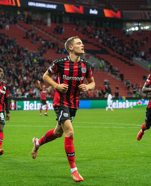 Leverkusens Torschütze Florian Wirtz (M) jubelt nach seinem Treffer zur 2:1 Führung. Daneben laufen Jeremie Frimpong (l) und Moussa Diaby.