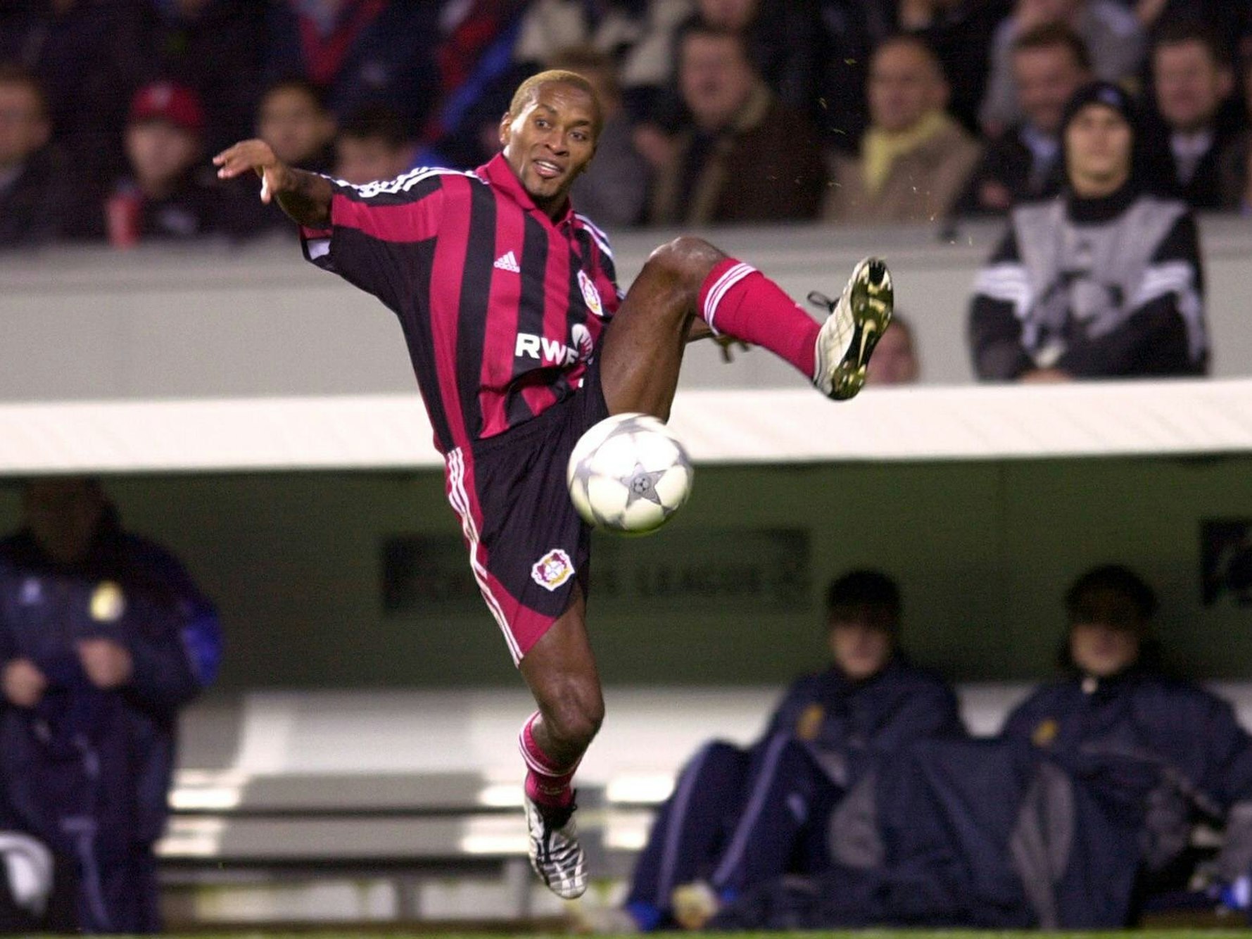 Leverkusens Zé Roberto springt mit gespreizten Beinen zum Ball.