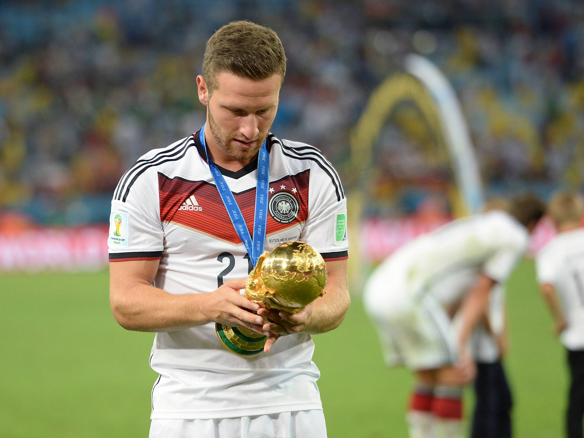 Mustafi schaut sich intensiv den WM-Pokal an.