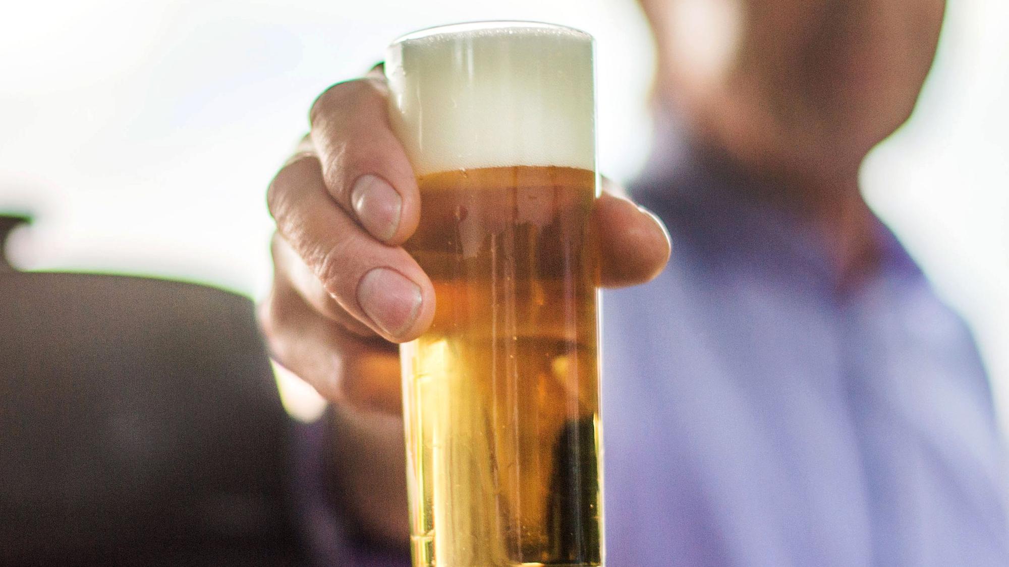 Mann hält Kölschglas in die Kamera. Foto von der dpa, honorarfrei