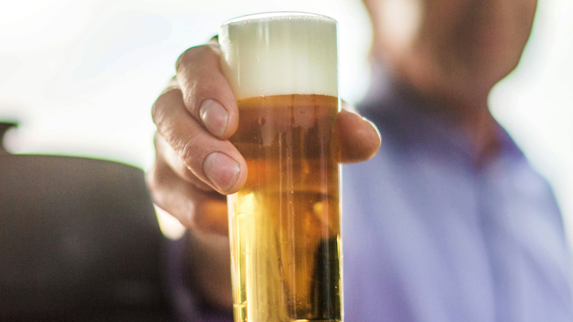 Mann hält Kölschglas in die Kamera. Foto von der dpa, honorarfrei