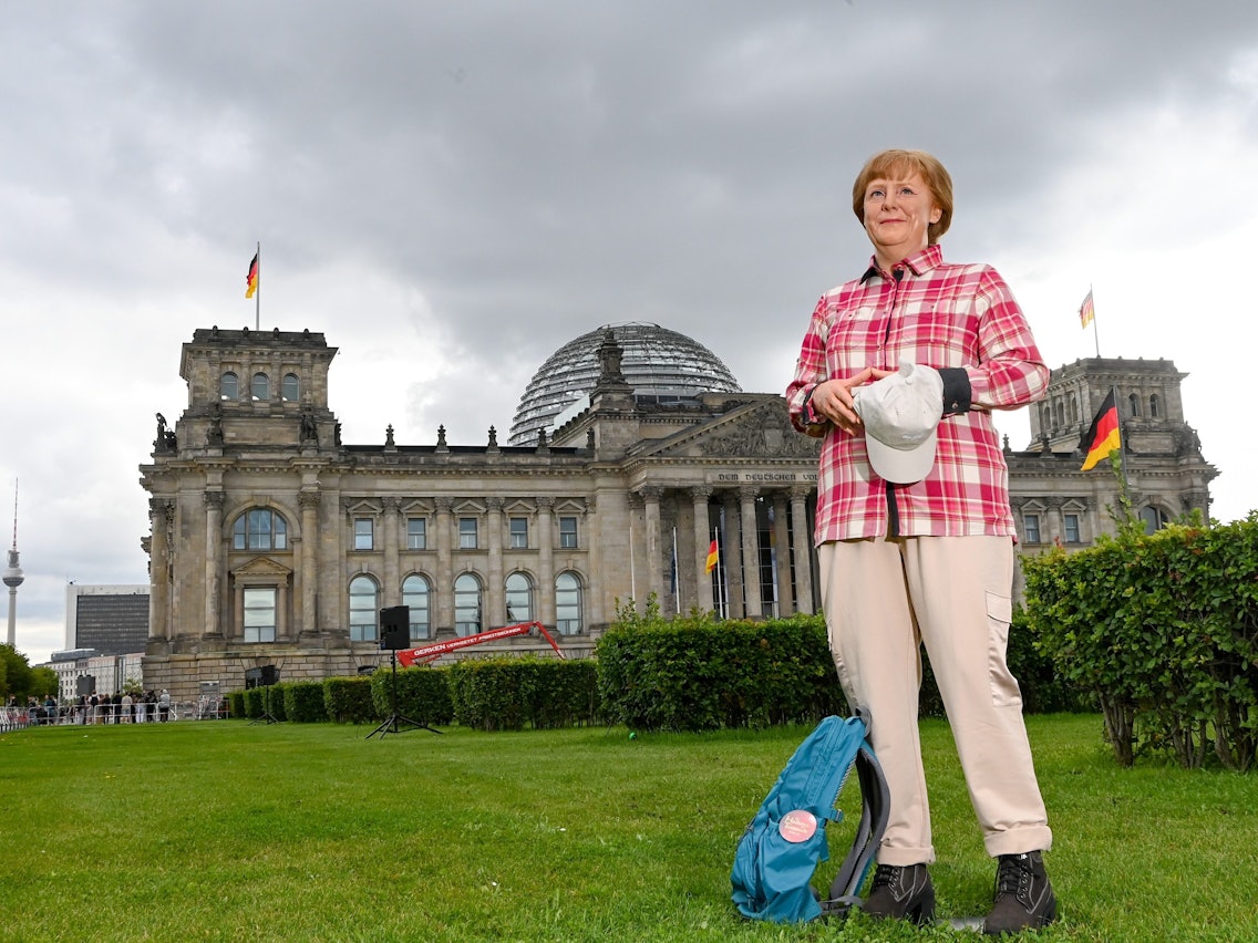 Die Wachsfigur von Bundeskanzlerin Angela Merkel (CDU) aus Madame Tussauds Berlin steht im Freizeitlook mit Rucksack, Basecap vor dem Reichstagsgebäude.