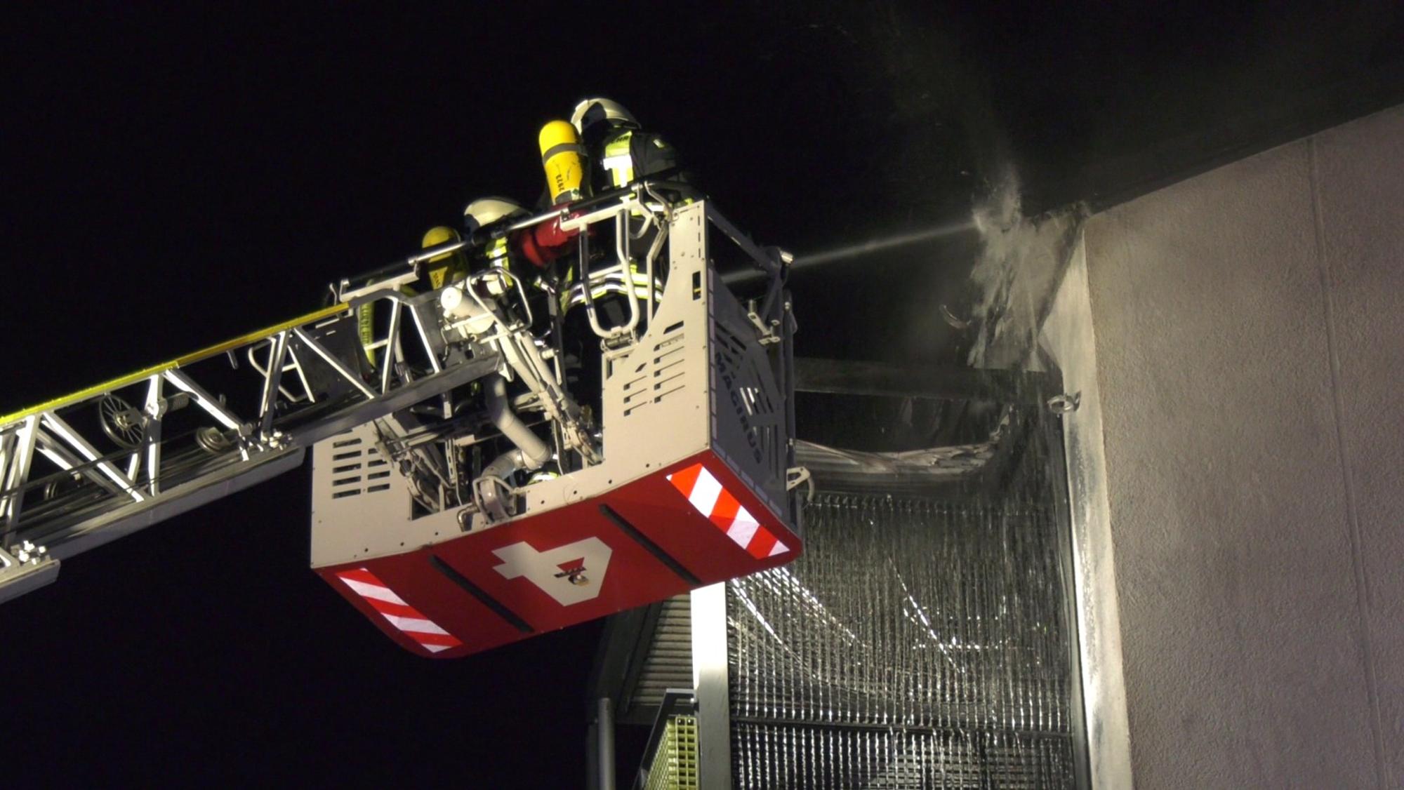 Feuerwehrmänner löschen über die Drehleiter.