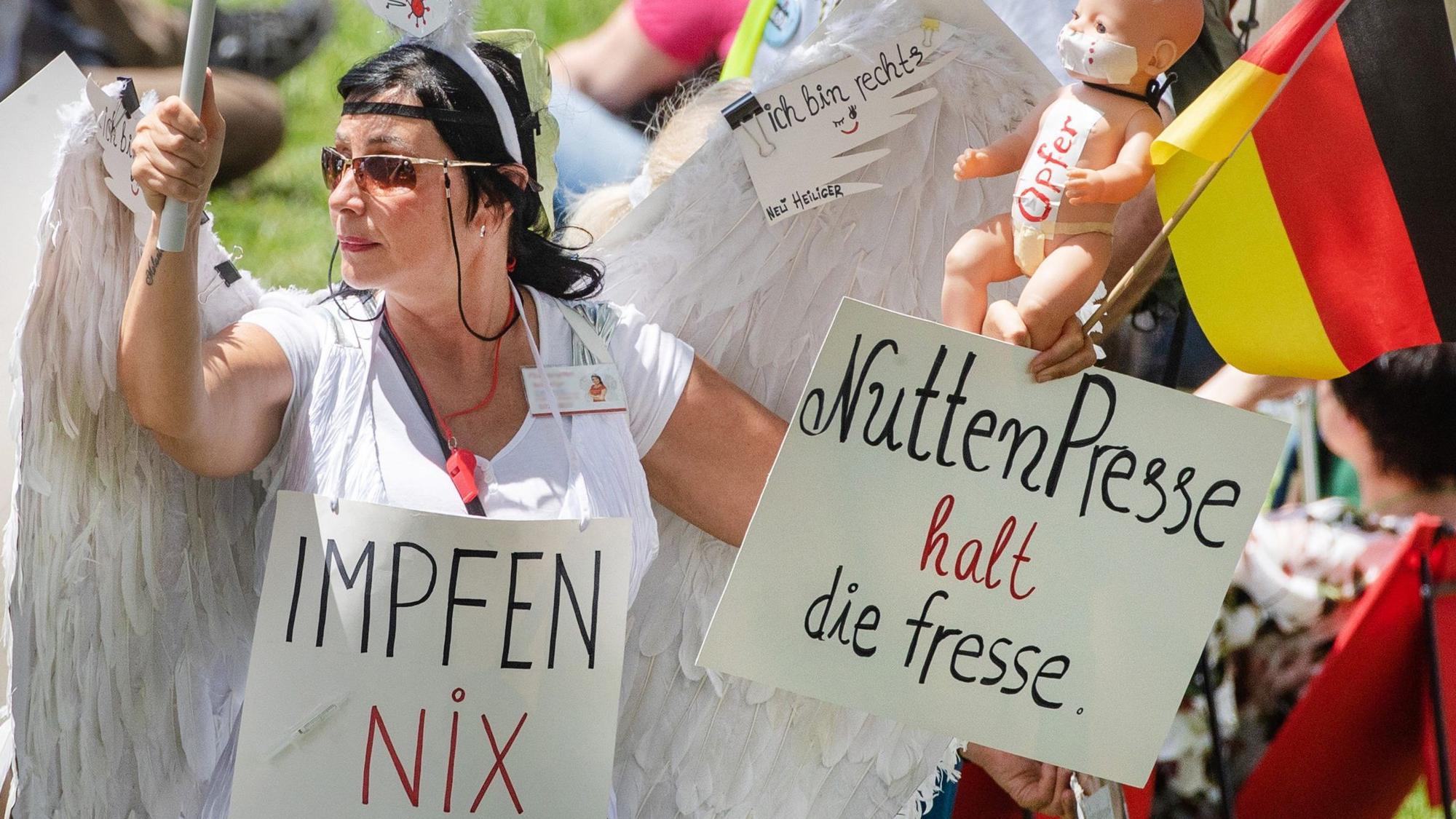 ARCHIV - 03.06.2021, Baden-Württemberg, Karlsruhe: "Impfen Nix Gut" und "Nutten Presse halt die fresse" steht auf dem Schild einer Demonstrantin, die an einer Demonstration der Initiative ·Querdenken· teilnimmt. (zu dpa "Facebook löscht «Querdenken»-Kanäle als «schädliches Netzwerk»") Foto: Christoph Schmidt/dpa +++ dpa-Bildfunk +++