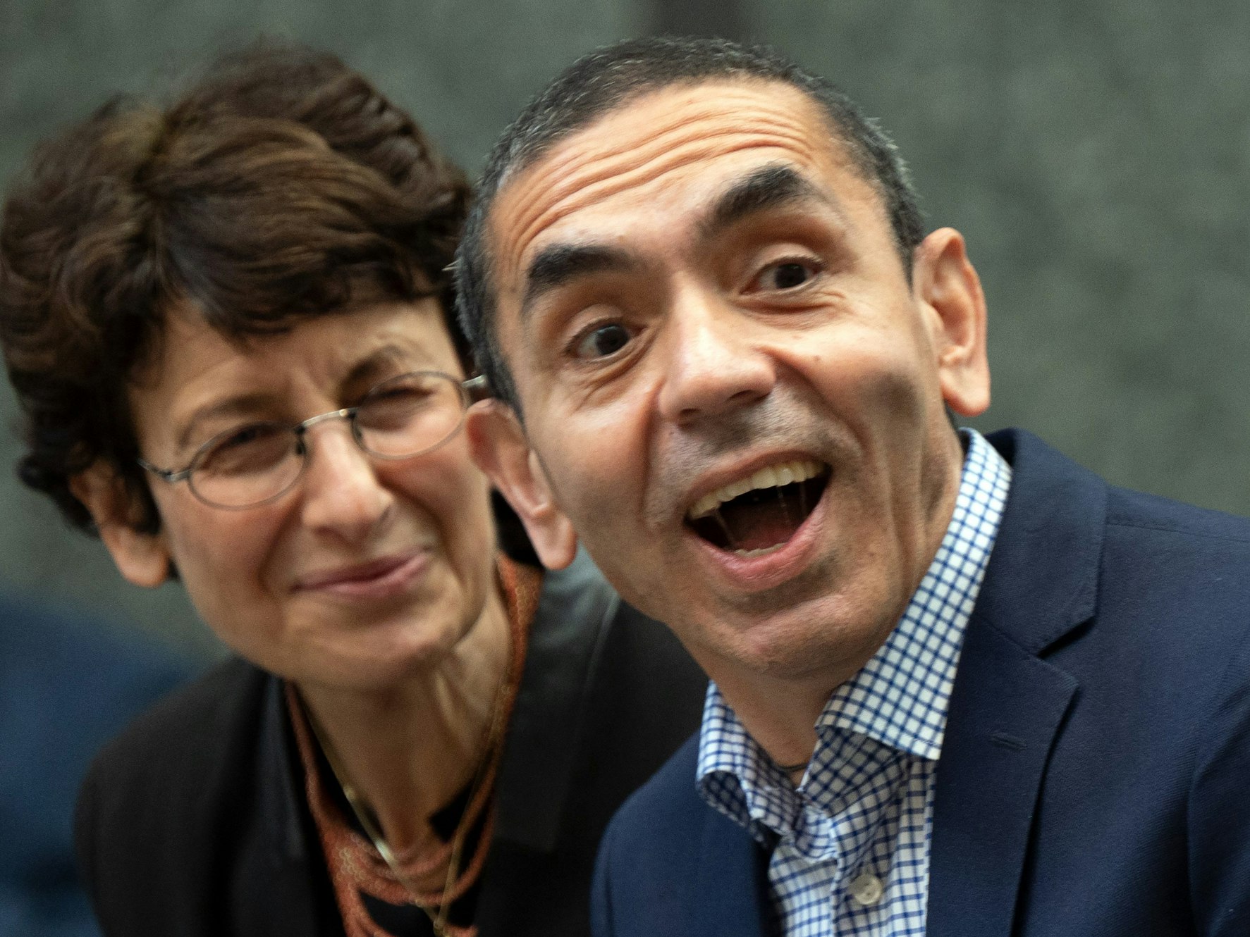 Ugur Sahin und Özlem Türeci lachen bei Feierlichkeit in Köln.