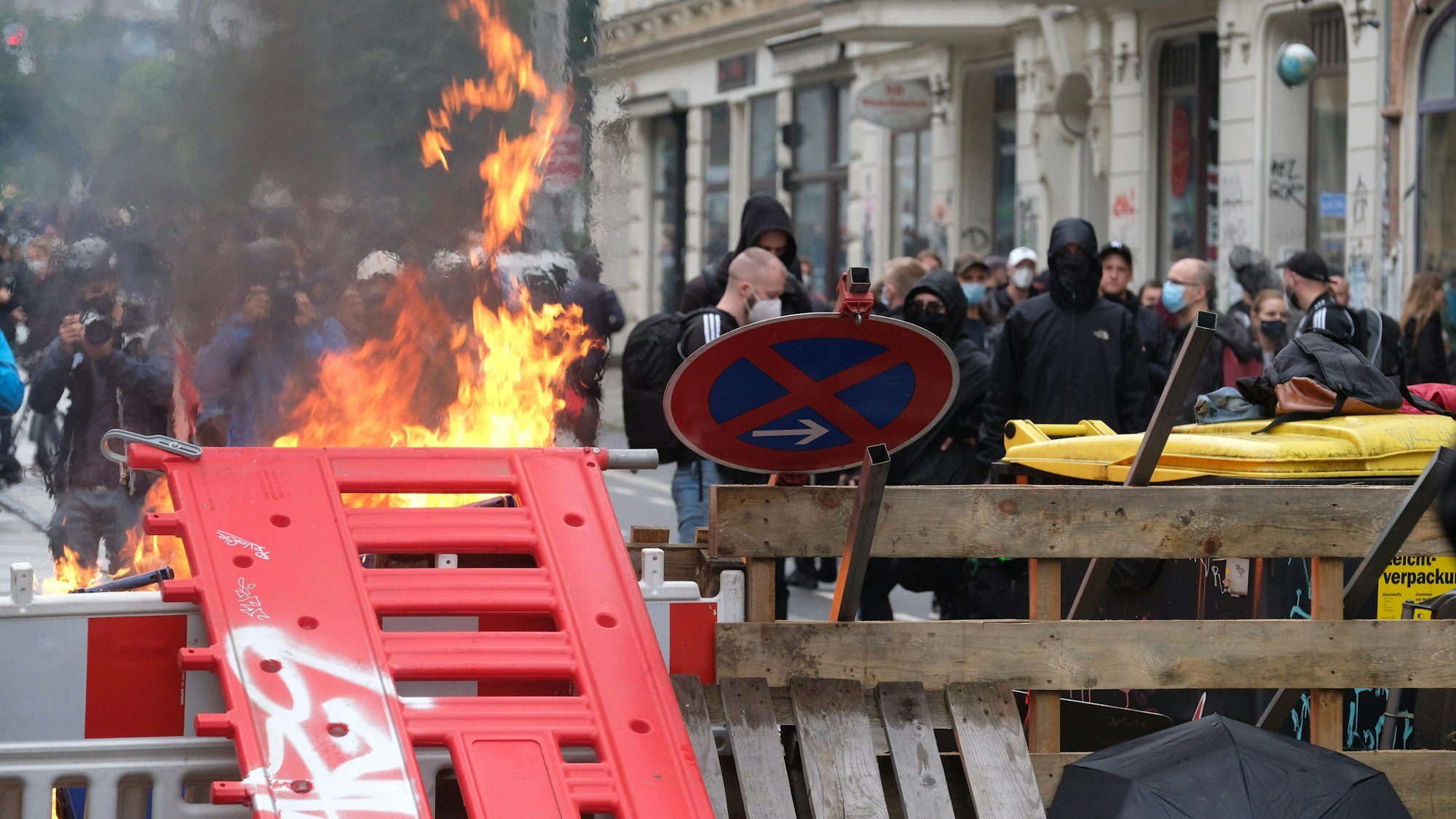 18.09.2021, Sachsen, Leipzig: Maskierte Teilnehmer stehen hinter einer Barrikade.
