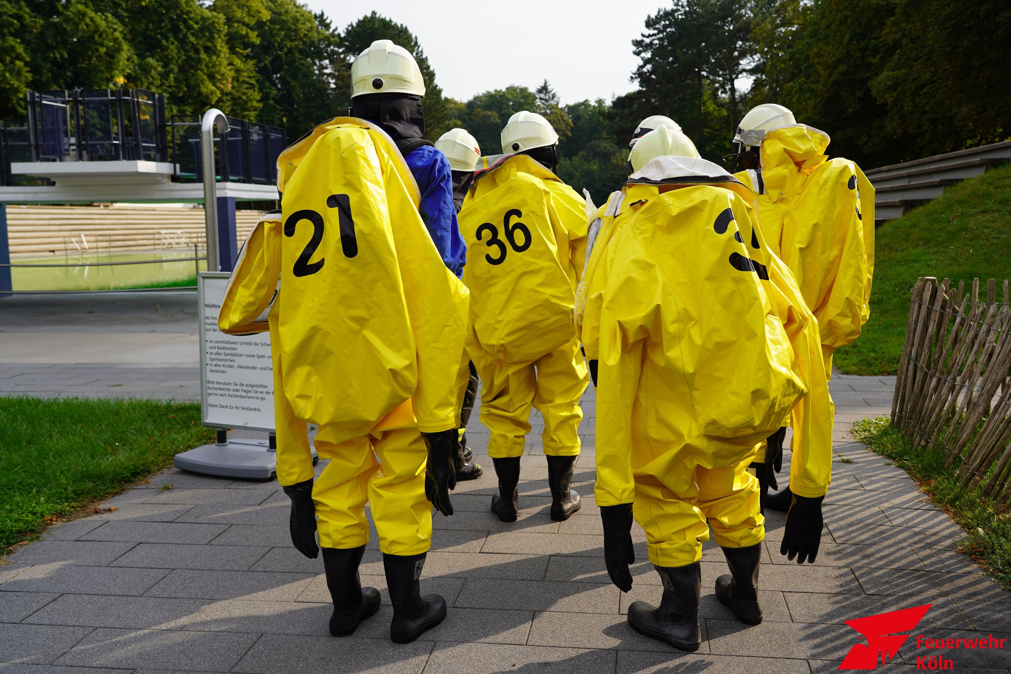 Feuerwehrmänner ziehen knallgelbe Schutzanzüge an.