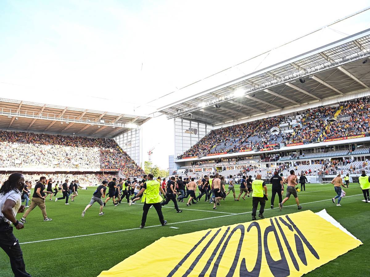 Fans des RC Lens stürmen beim Spiel gegen Lille das Spielfeld.