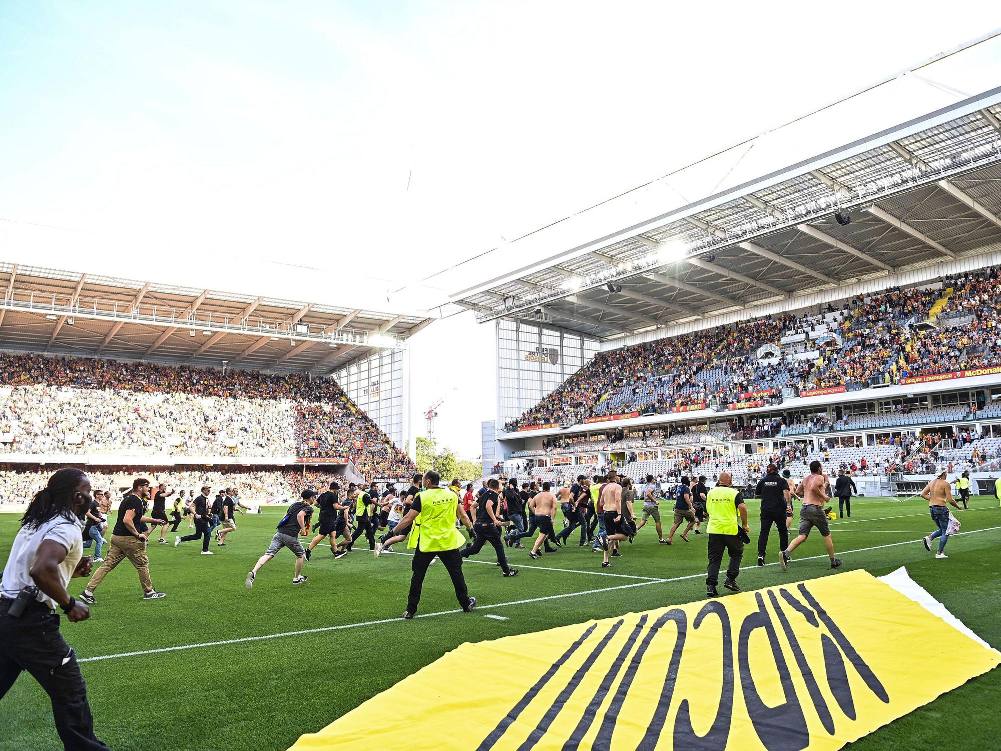 Fans des RC Lens stürmen beim Spiel gegen Lille das Spielfeld.