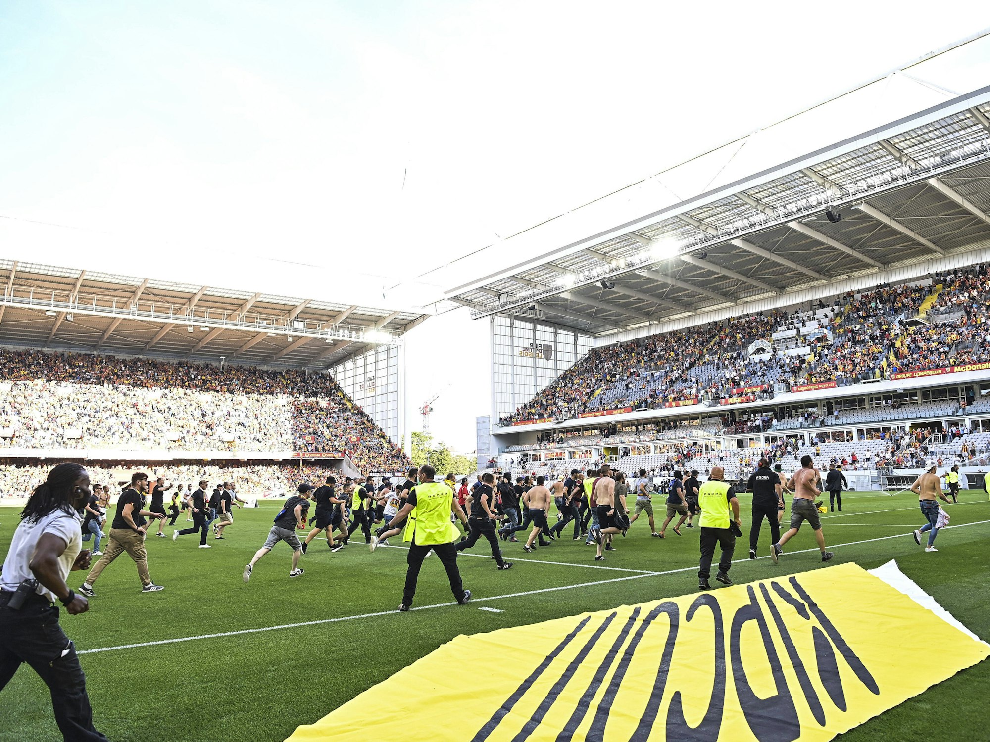 Fans des RC Lens stürmen beim Spiel gegen Lille das Spielfeld.