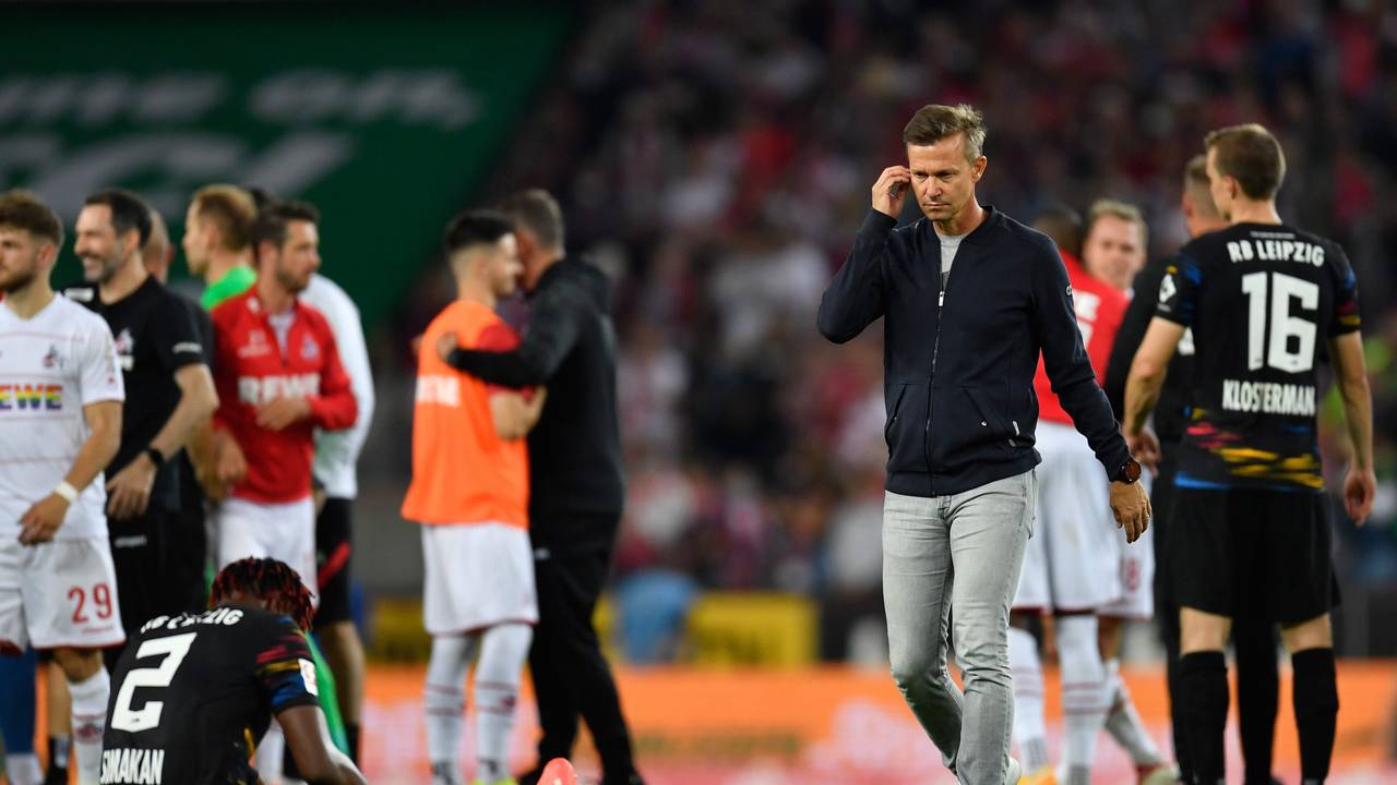 Leipzigs Trainer Jesse Marsch (r) geht nach dem Spiel über den Platz. Links sitzt Leipzigs Mohamed Simakan auf dem Rasen.