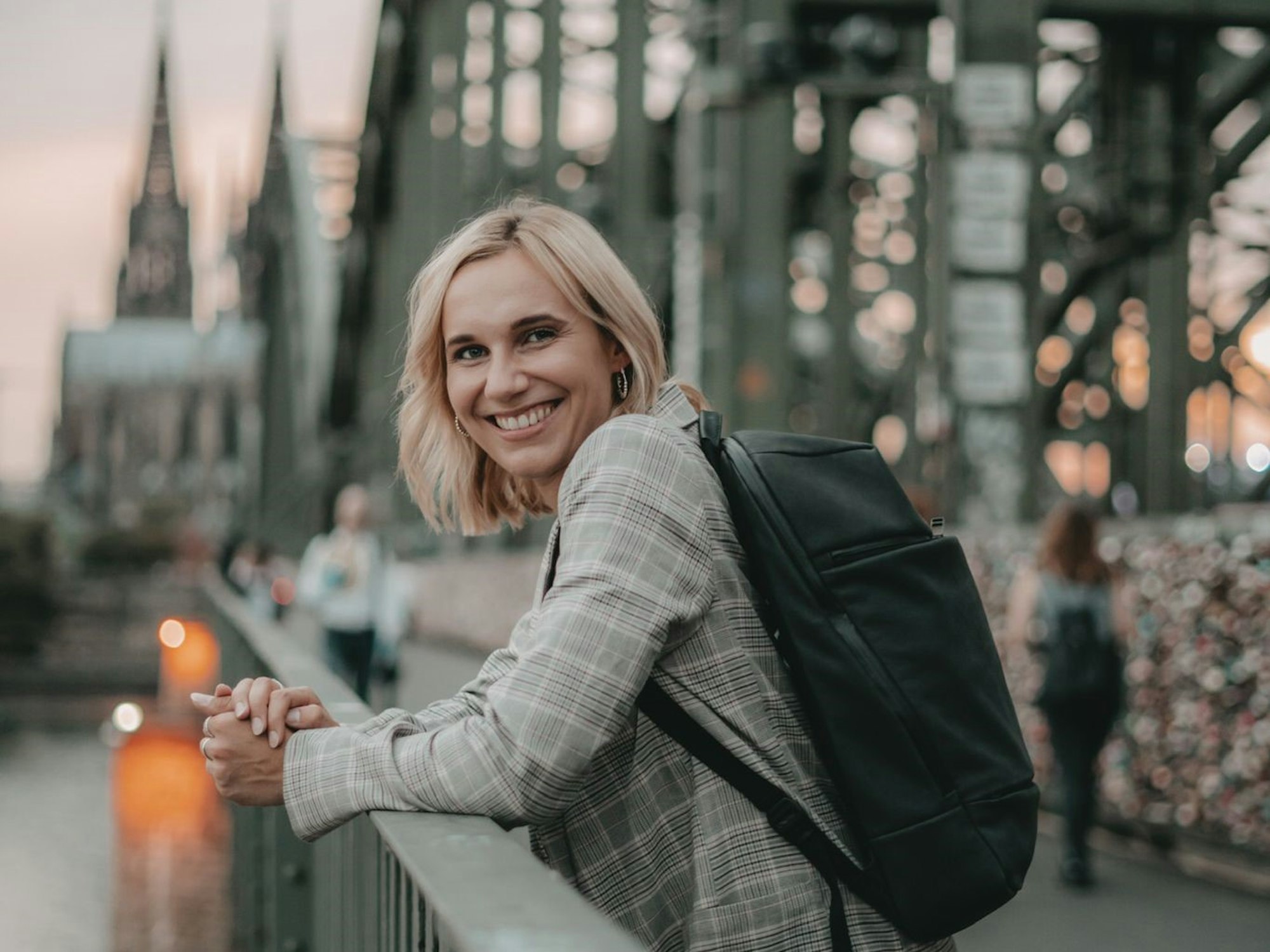 Lena Brabender (26) steht auf einer Brücke, im Hintergrund der Kölner Dom.
