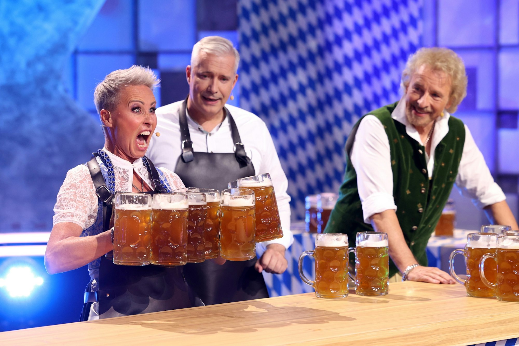 Sonja Zietlow versucht so viele Bierkrüge wie möglich zu stemmen.