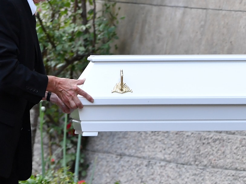 Bestatter tragen einen Kindersarg.