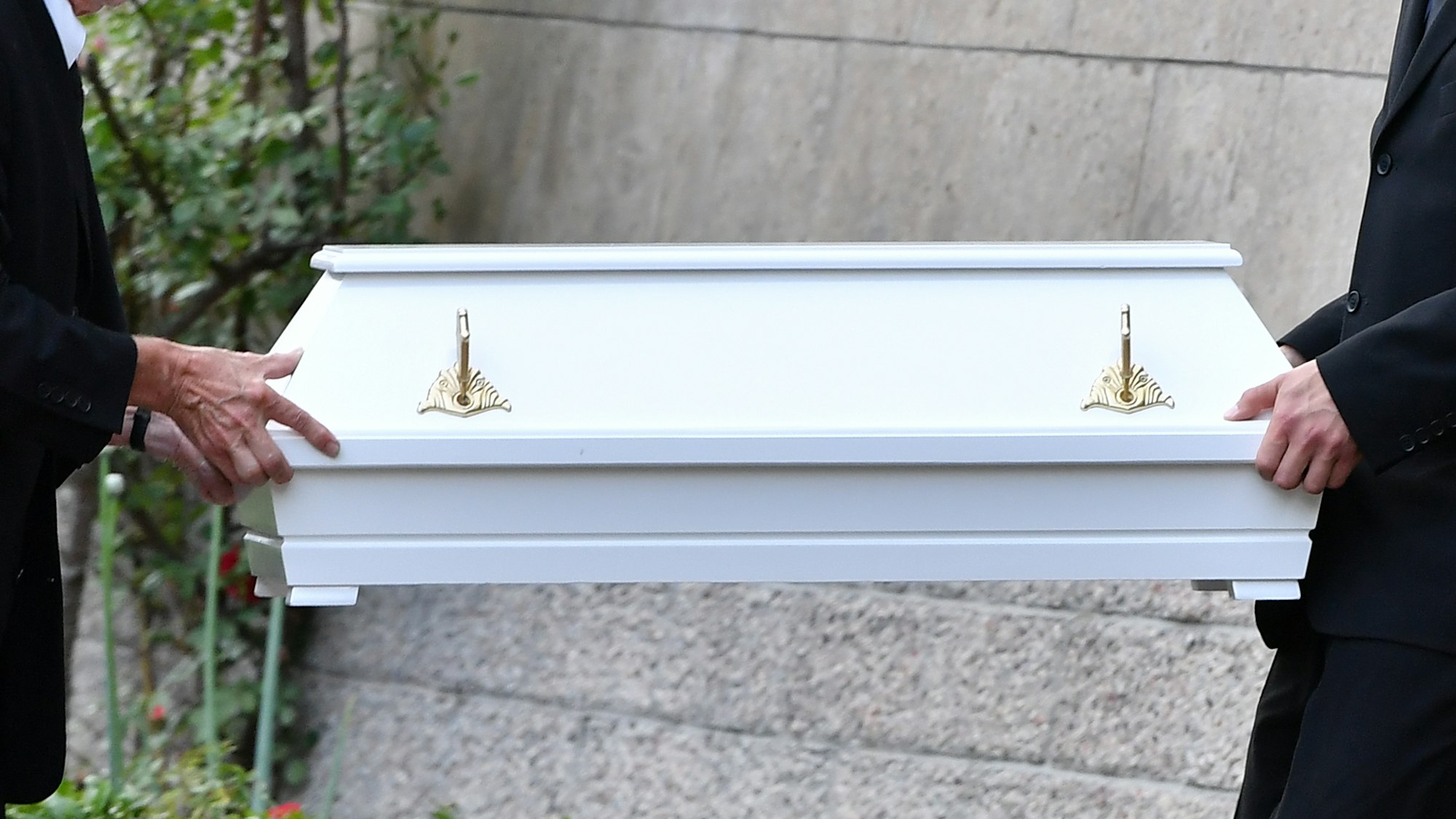 Bestatter tragen einen Kindersarg.