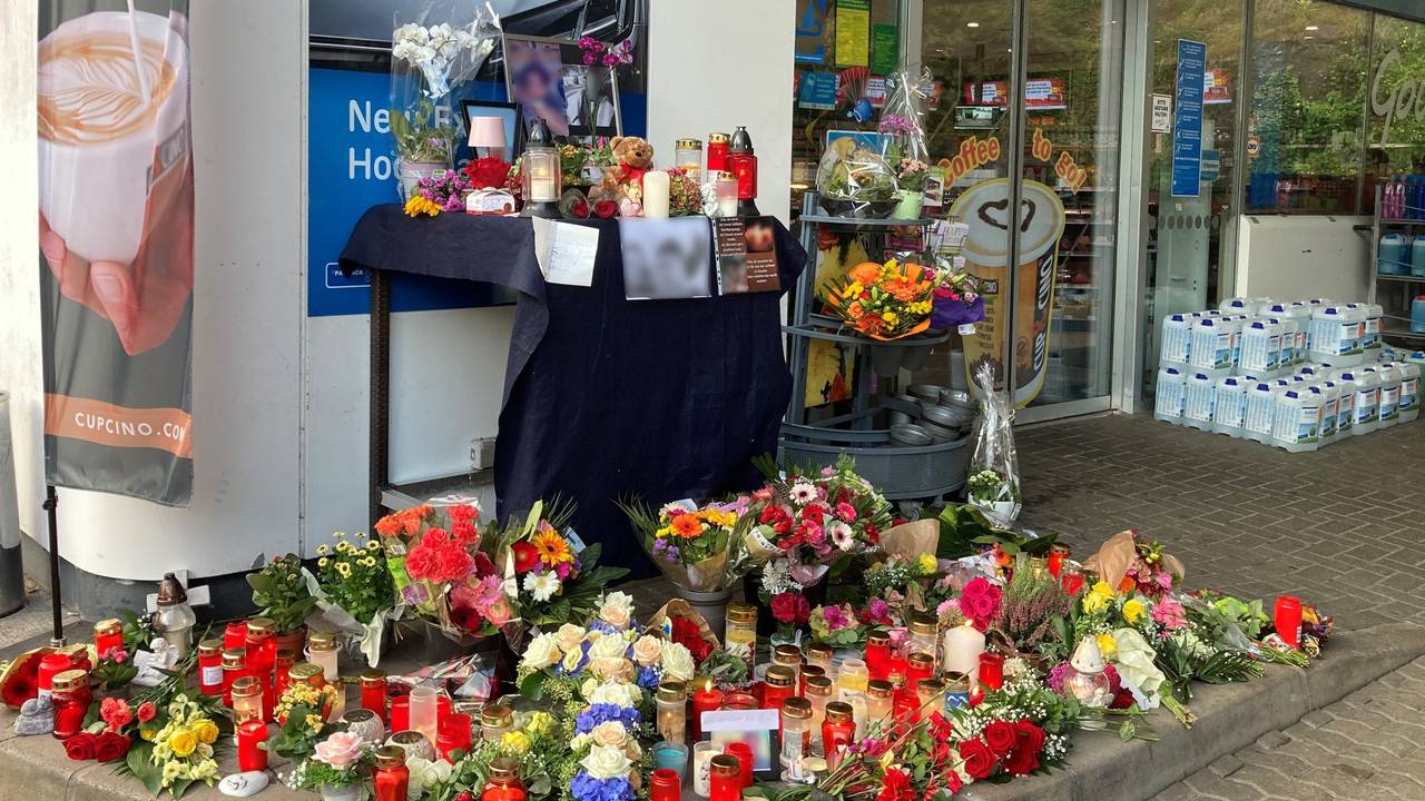 Blumen und Kerzen sind vor der Tankstelle aufgestellt, in der ein 20-jähriger Kassierer mit einem Kopfschuss getötet wurde.