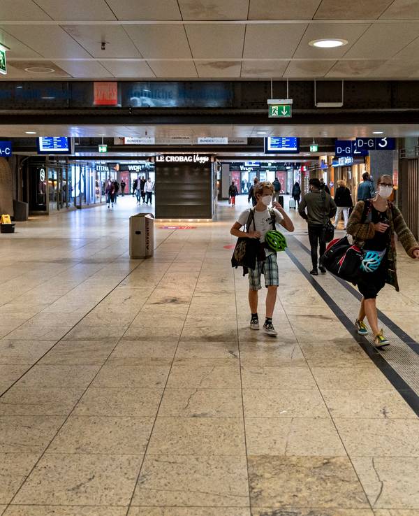 Menschen mit Gepäck gehen durch den Kölner Hauptbahnhof.