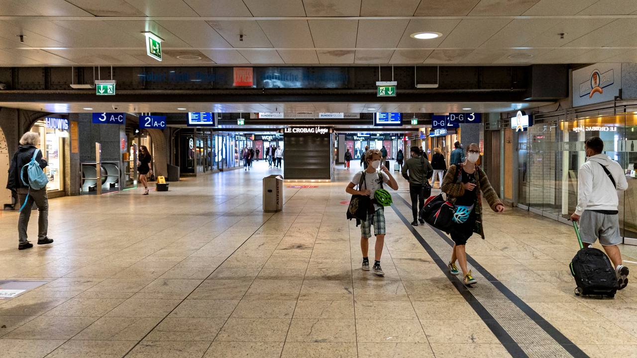Menschen mit Gepäck gehen durch den Kölner Hauptbahnhof.