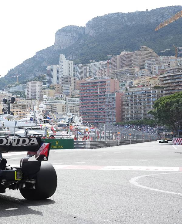 Ein Formel-1-Rennauto fährt durch Monaco. Im Hintergrund sind Yachten und Häuser zu sehen.