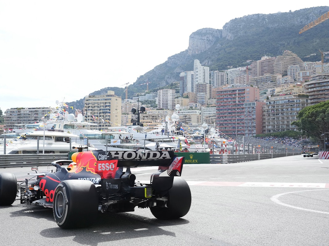 Ein Formel-1-Rennauto fährt durch Monaco. Im Hintergrund sind Yachten und Häuser zu sehen.