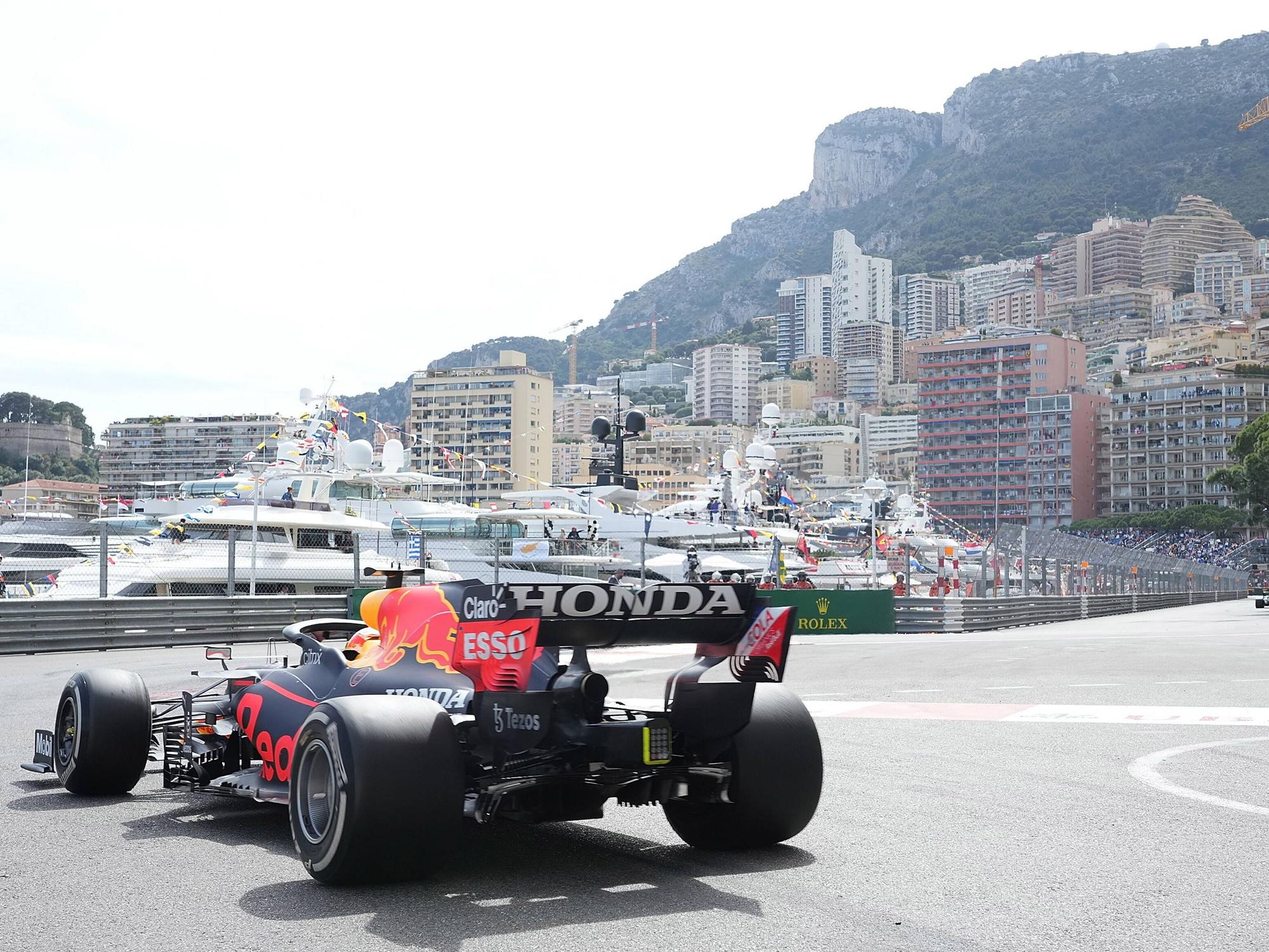 Ein Formel-1-Rennauto fährt durch Monaco. Im Hintergrund sind Yachten und Häuser zu sehen.