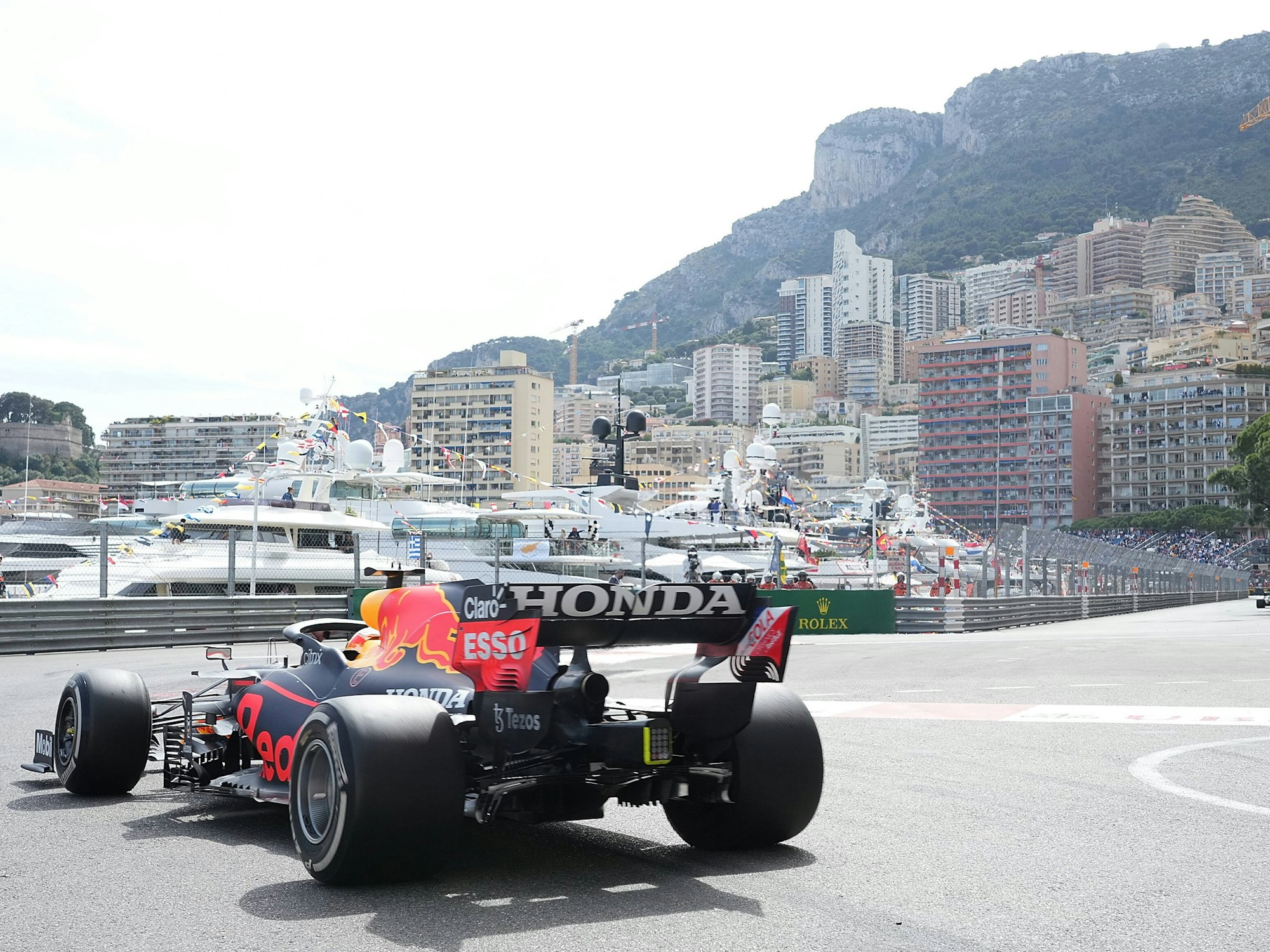 Ein Formel-1-Rennauto fährt durch Monaco. Im Hintergrund sind Yachten und Häuser zu sehen.