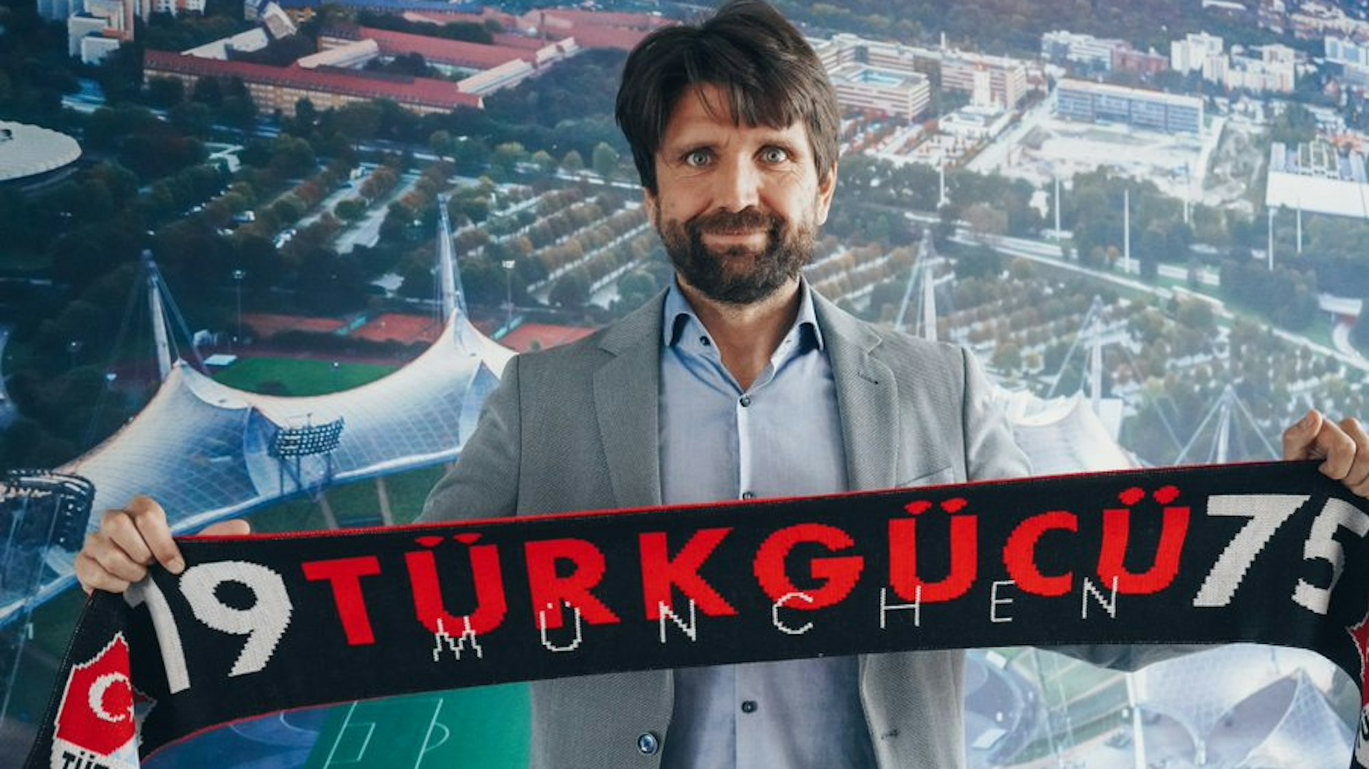 Trainer Peter Hyballa hält einen Schal seines neuen Vereins Türkgücü München hoch.