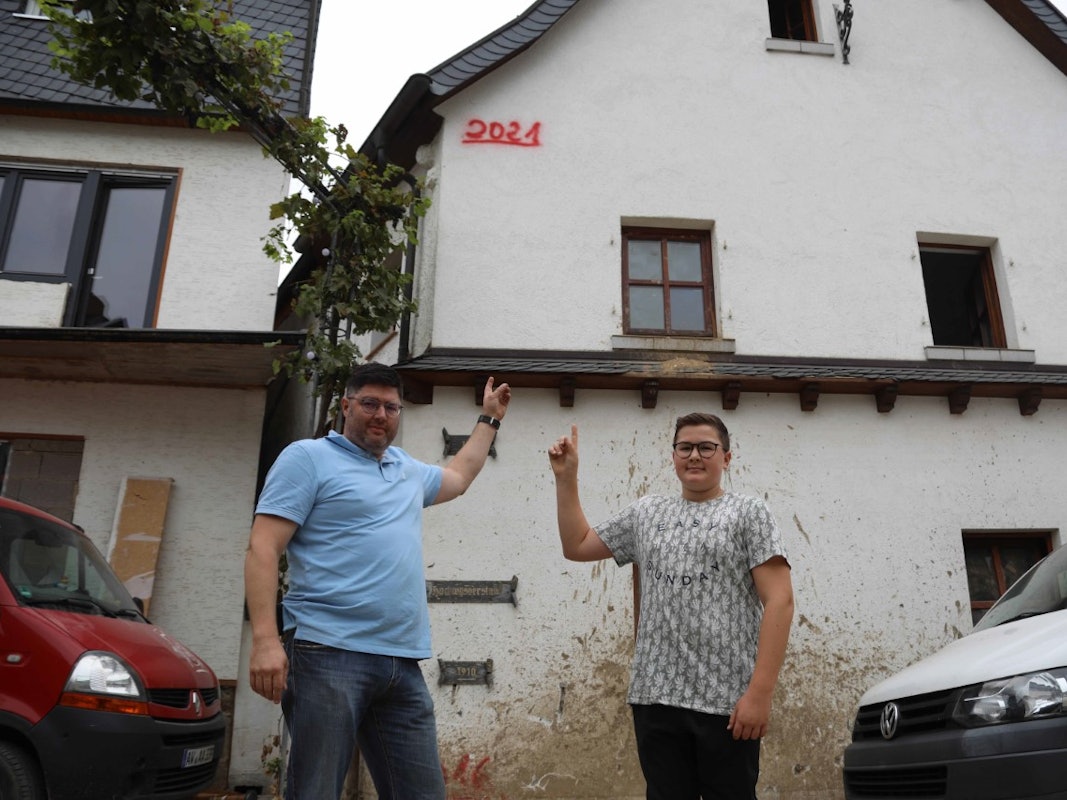 Familie in Dernau zeigt Pegelstand des Hochwassers von Juli 2021