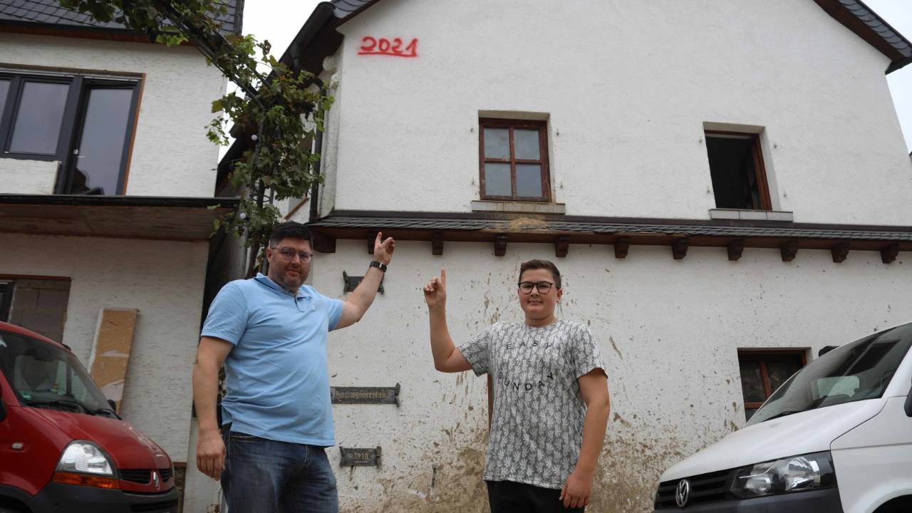 Familie in Dernau zeigt Pegelstand des Hochwassers von Juli 2021