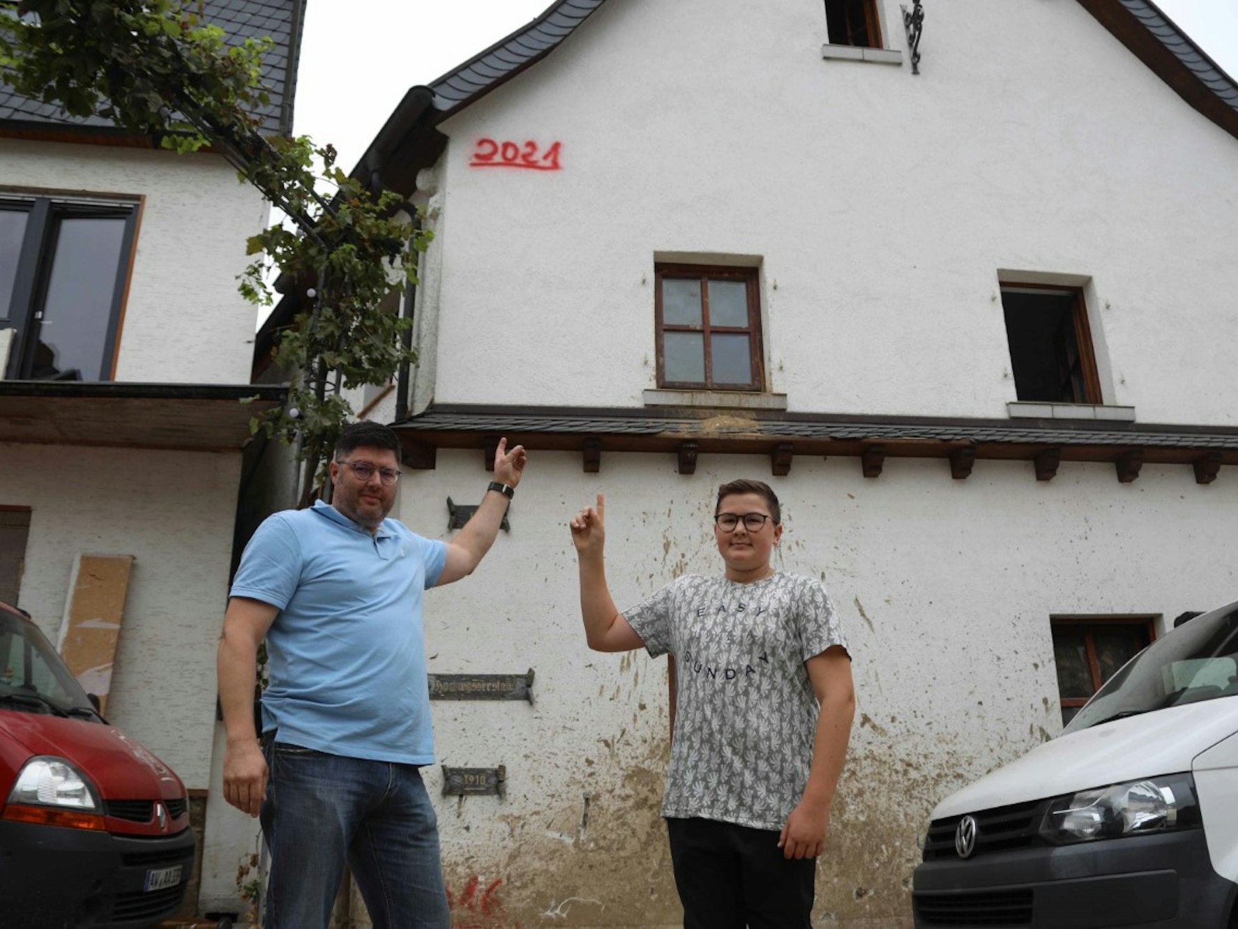 Familie in Dernau zeigt Pegelstand des Hochwassers von Juli 2021