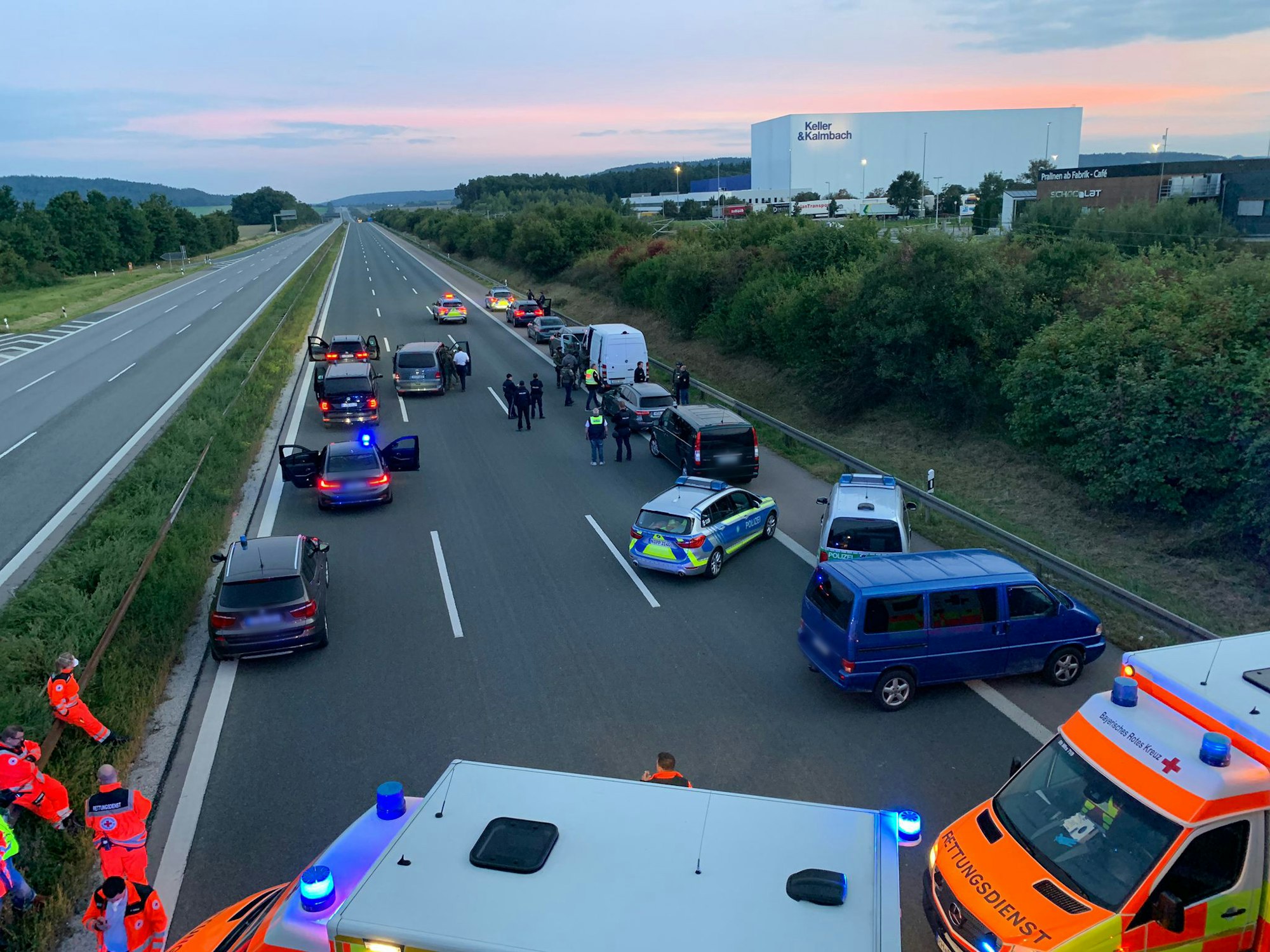 Polizisten und Helfer stehen mit ihren Fahrzeugen auf der Autobahn 9. Wegen eines mutmaßlich bewaffneten Passagiers in einem Reisebus hat die bayerische Polizei die Autobahn 9 zwischen den Anschlussstellen Hilpoltstein und Greding in beiden Fahrtrichtungen komplett gesperrt.